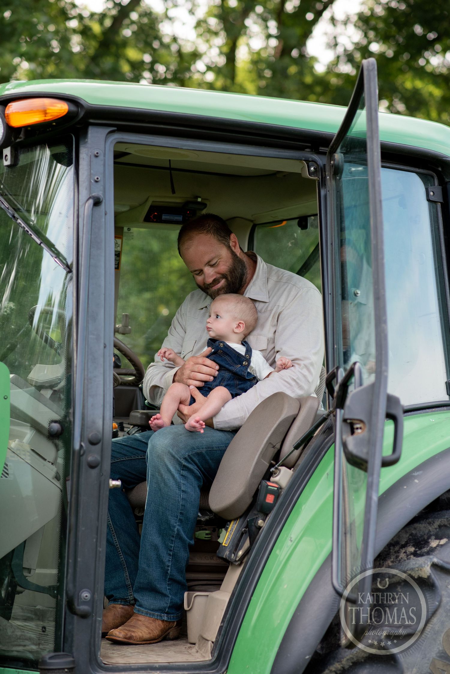 Parent and baby sharing tender moment in tractor cabin on farm.