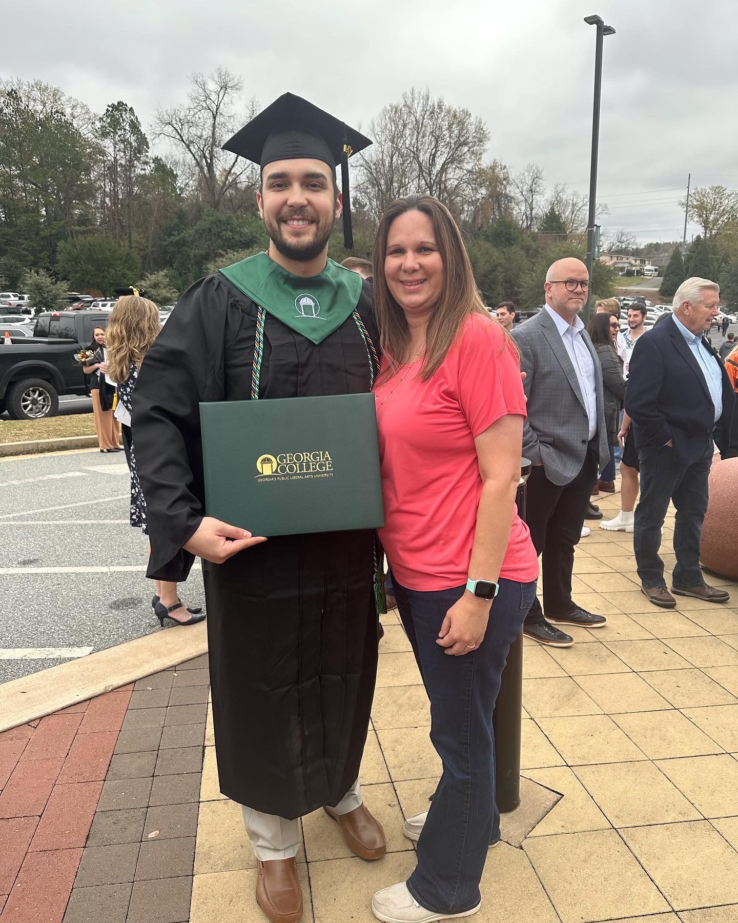 young man graduate holding degree standing with a lady