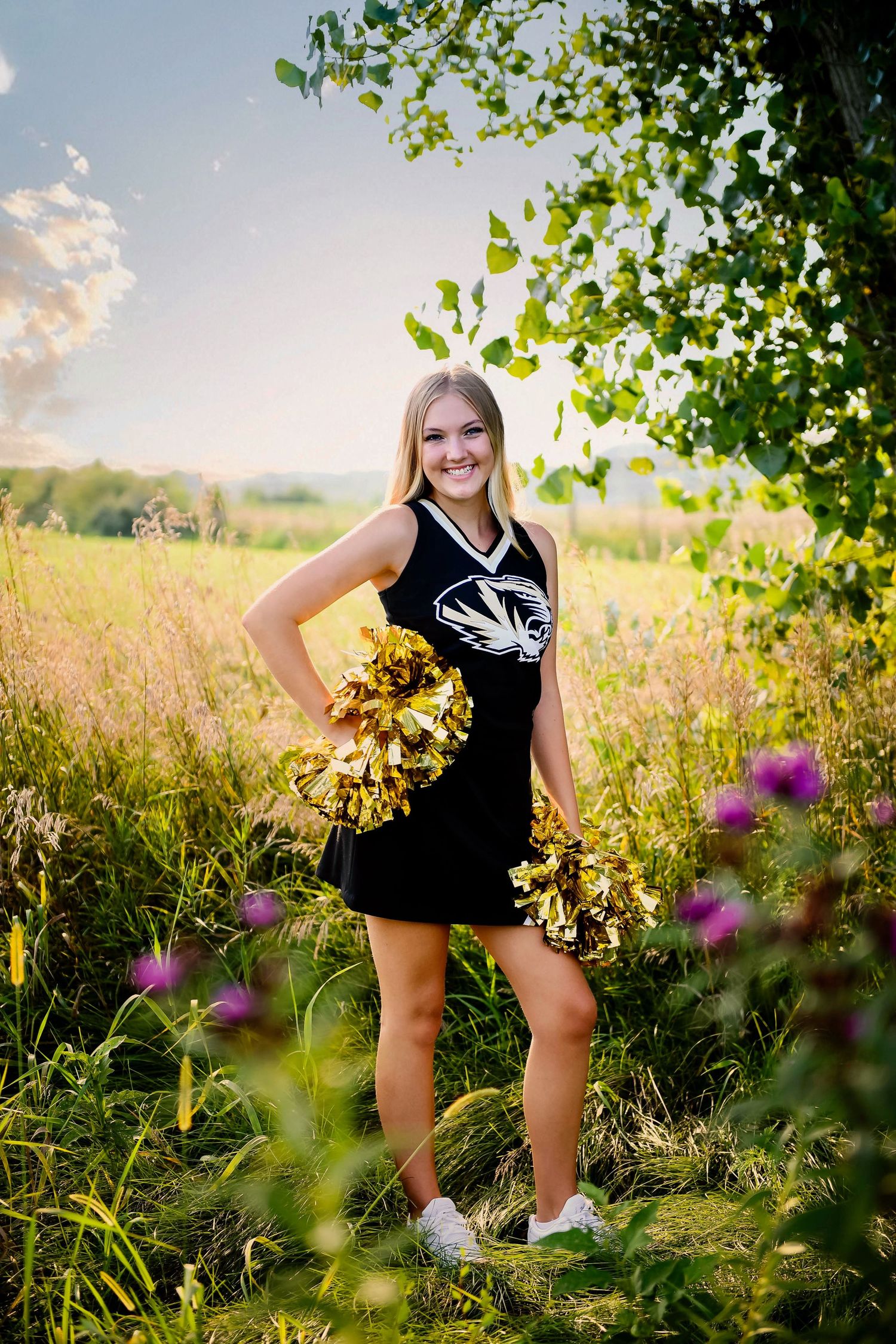 teenage girl in flower field wearing her high school cheerleading uniform