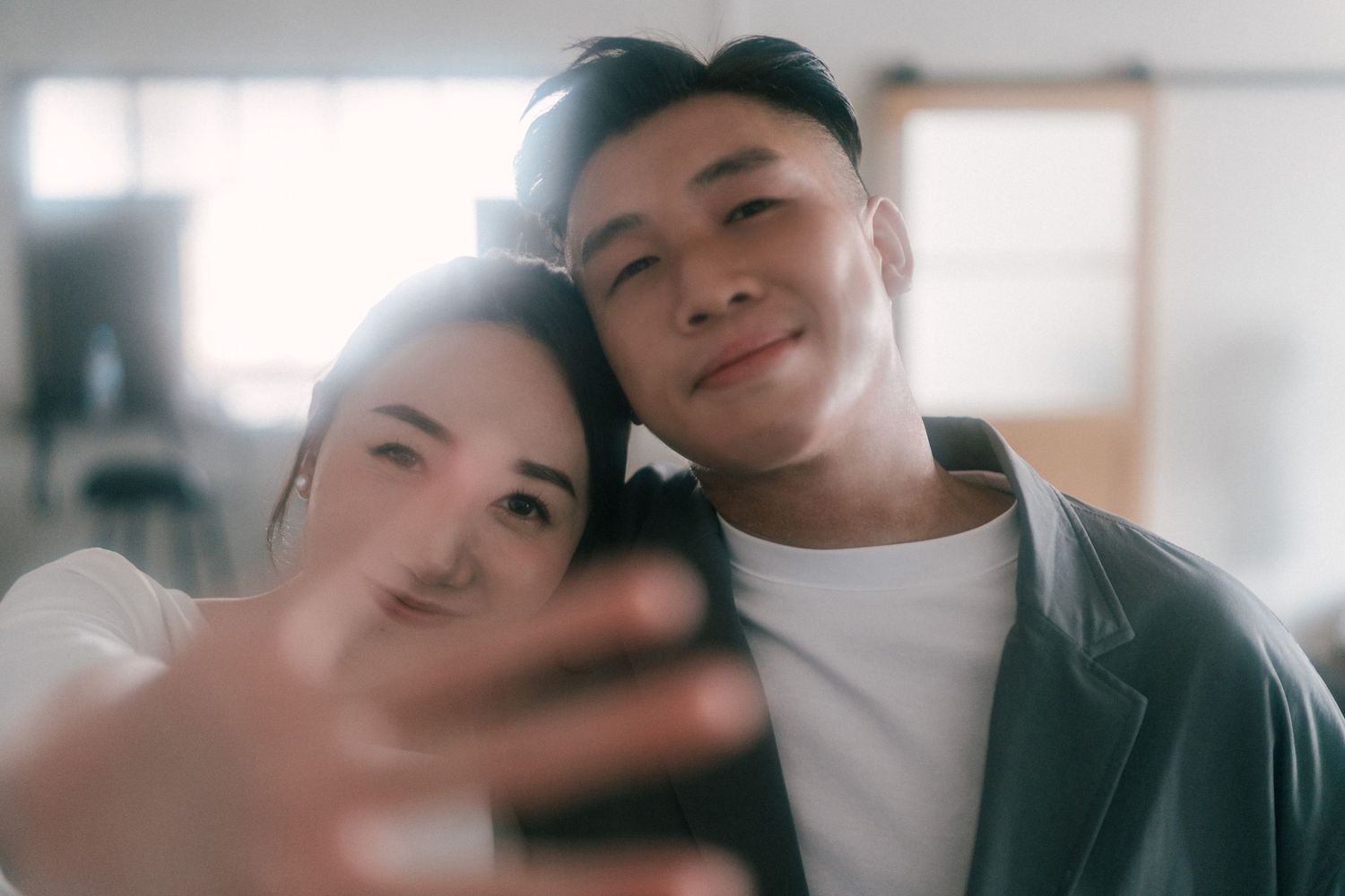 Close-up selfie moment with soft natural lighting in an indoor setting.