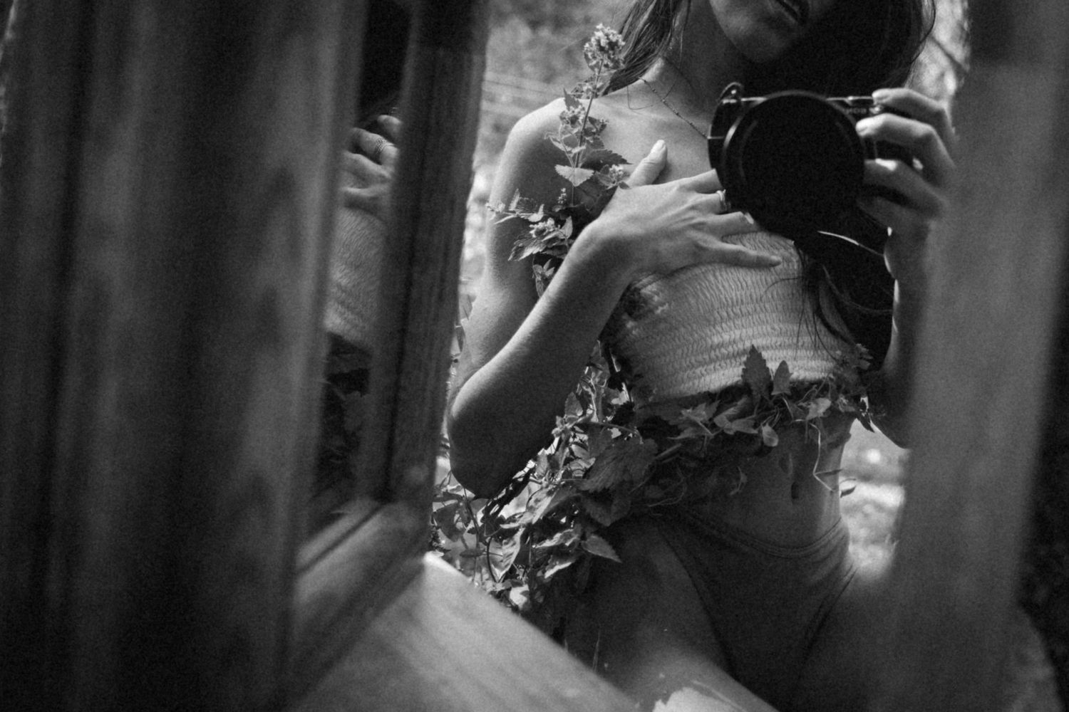 Artistic black and white photograph of delicate floral details on a flowing dress.