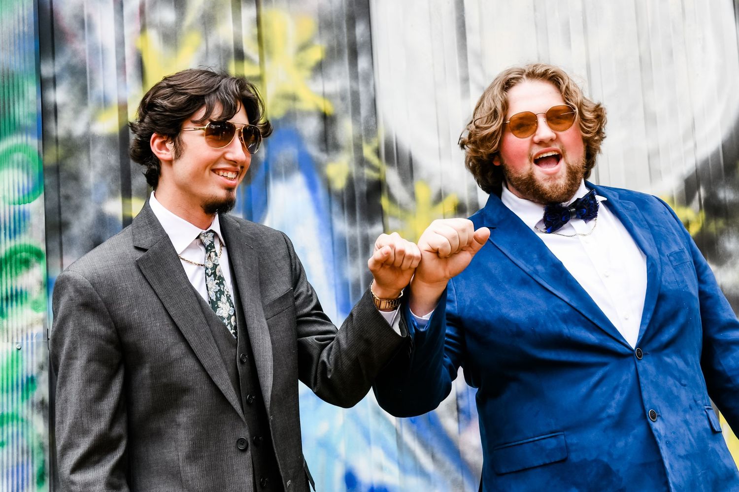Boys prom pictures in front of graffiti wall
