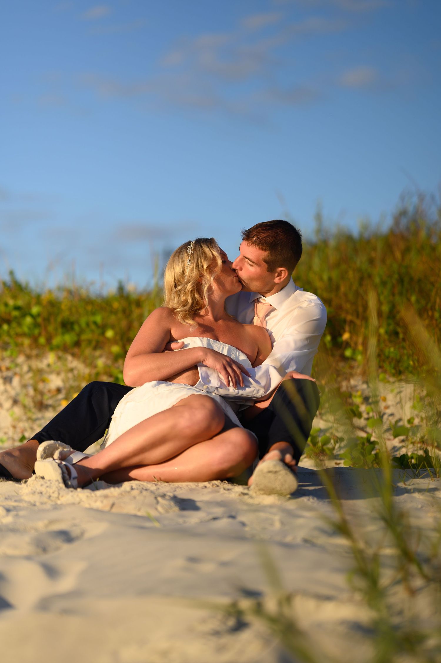 Bride and Groom kiss on sand dune.