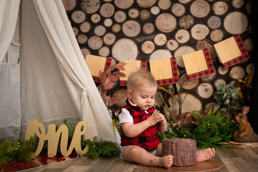 Holiday photo session with wooden decor, fairy lights and natural wood wall backdrop.