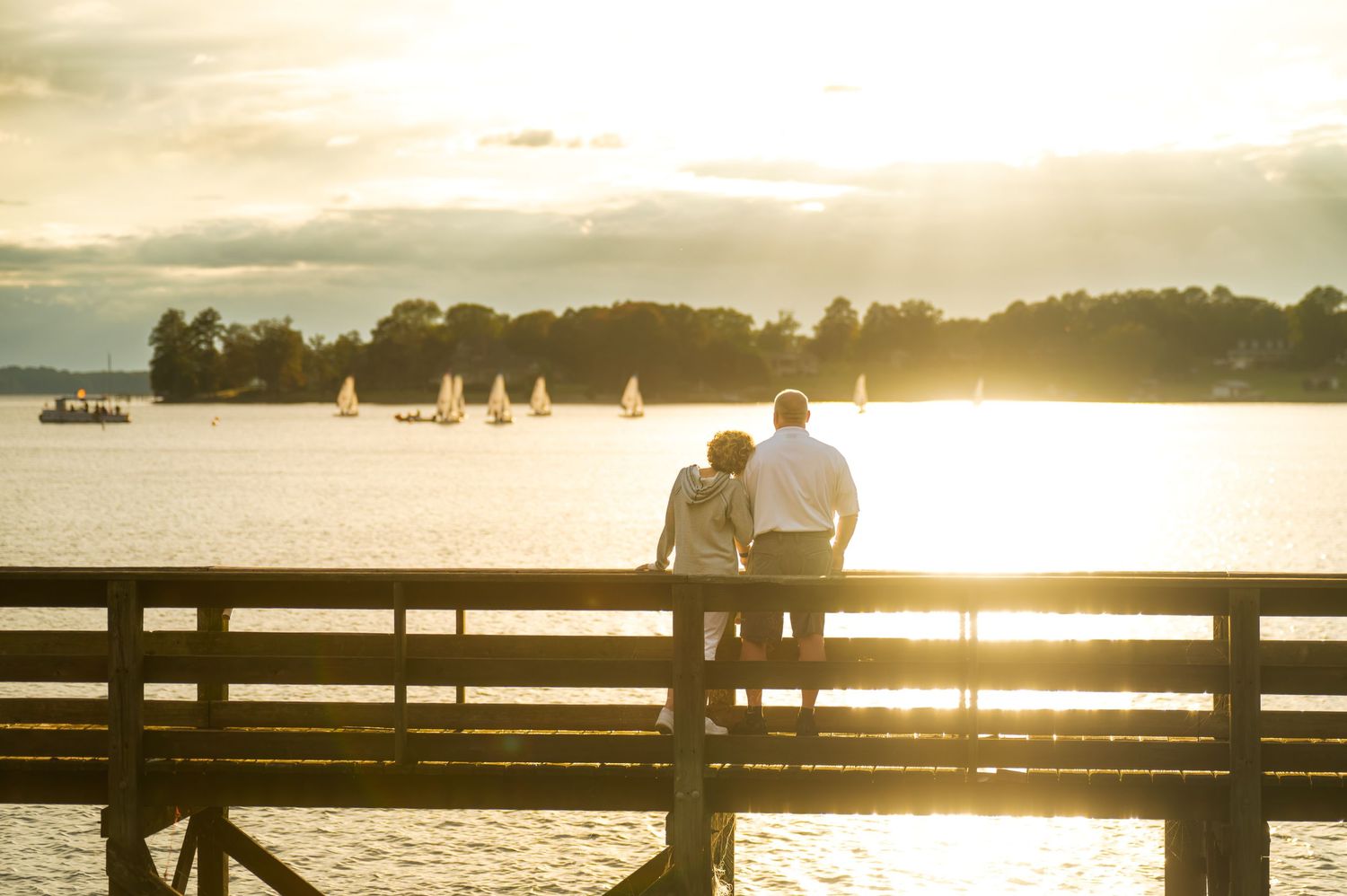 A couple stands on a wooden pier watching sailboats at sunset on a tranquil Lake Murray, South Carolina
Families, Couples, Elopements