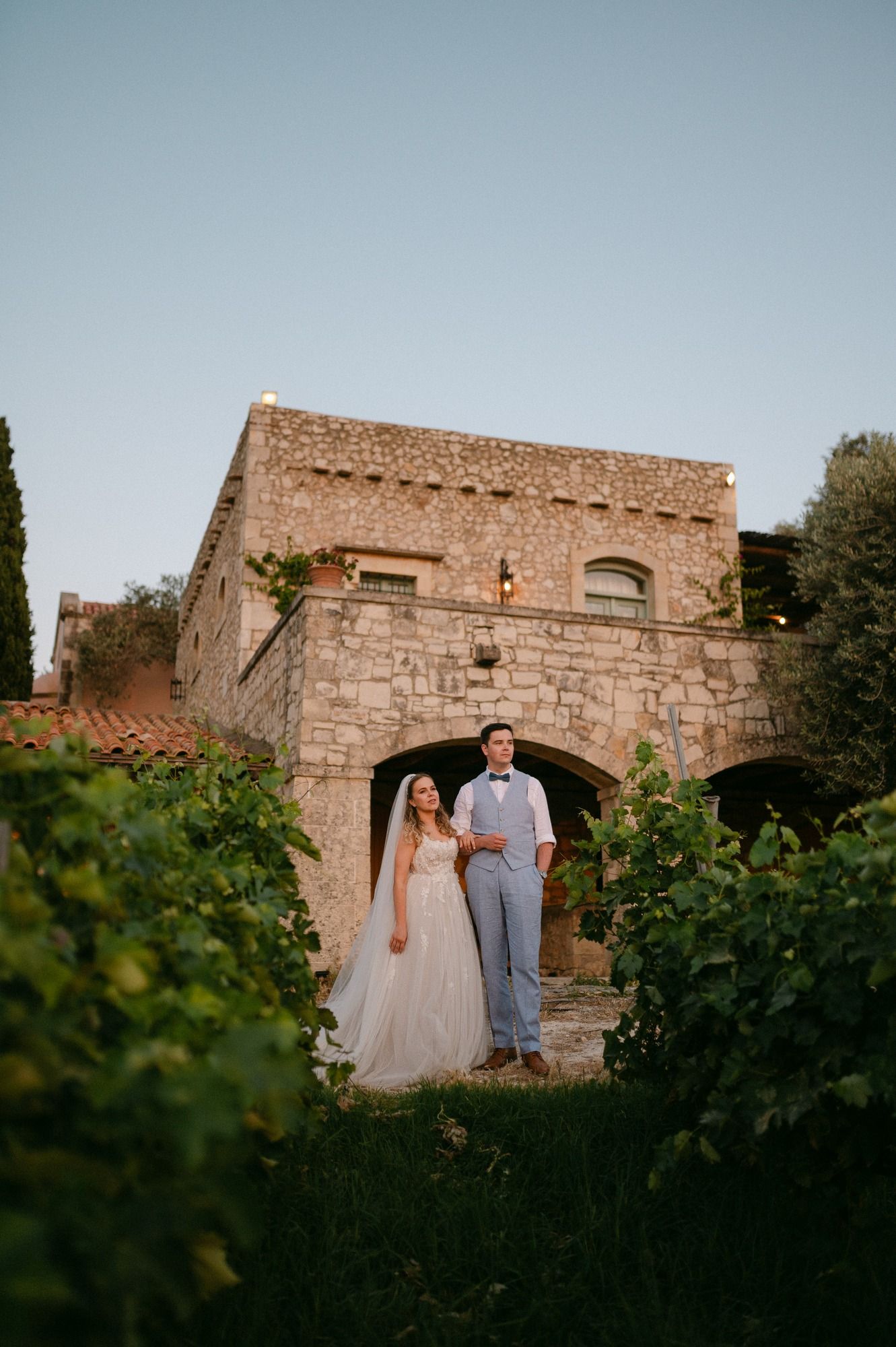 Beautiful Agreco Farms in Crete archway in a vineyard setting creates a romantic rustic backdrop at sunset for a wedding.