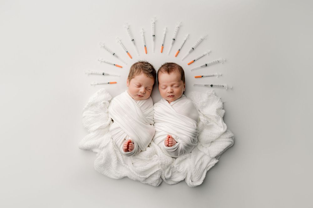 Twins laying on a bed posing for Jacksonville baby photographer, Ashley Wilson