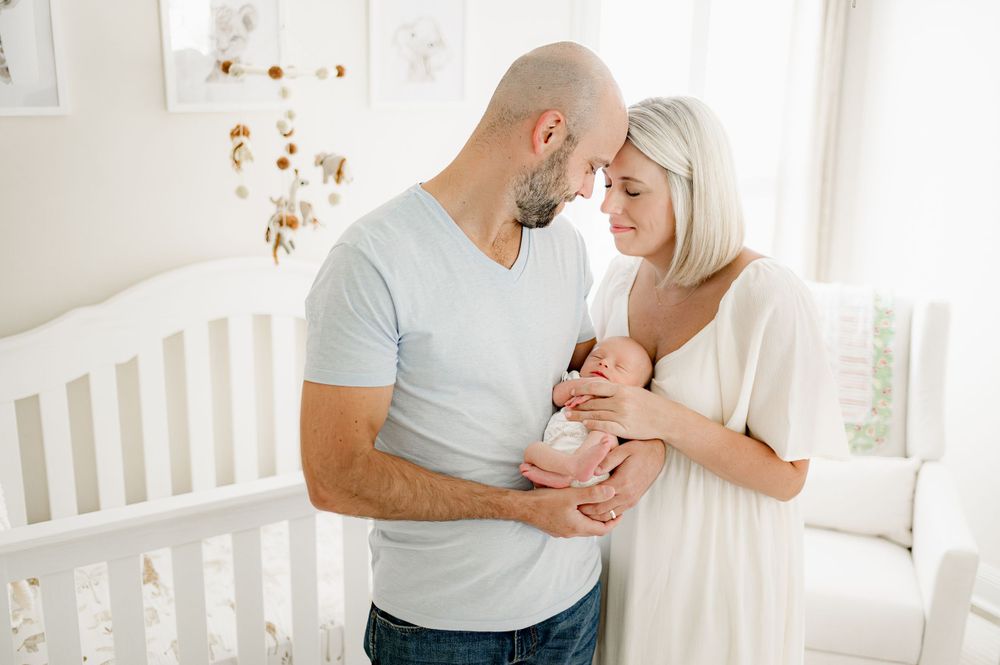 Couple embracing newborn baby, taken by Jacksonville infant photographer Ashley Wilson