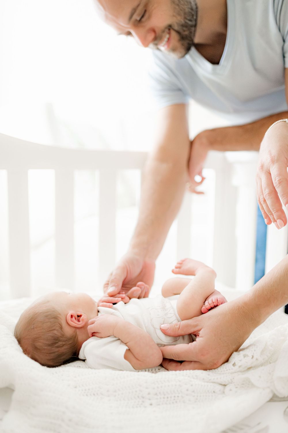 Father playing with newborn baby, taken by Jacksonville baby photographer