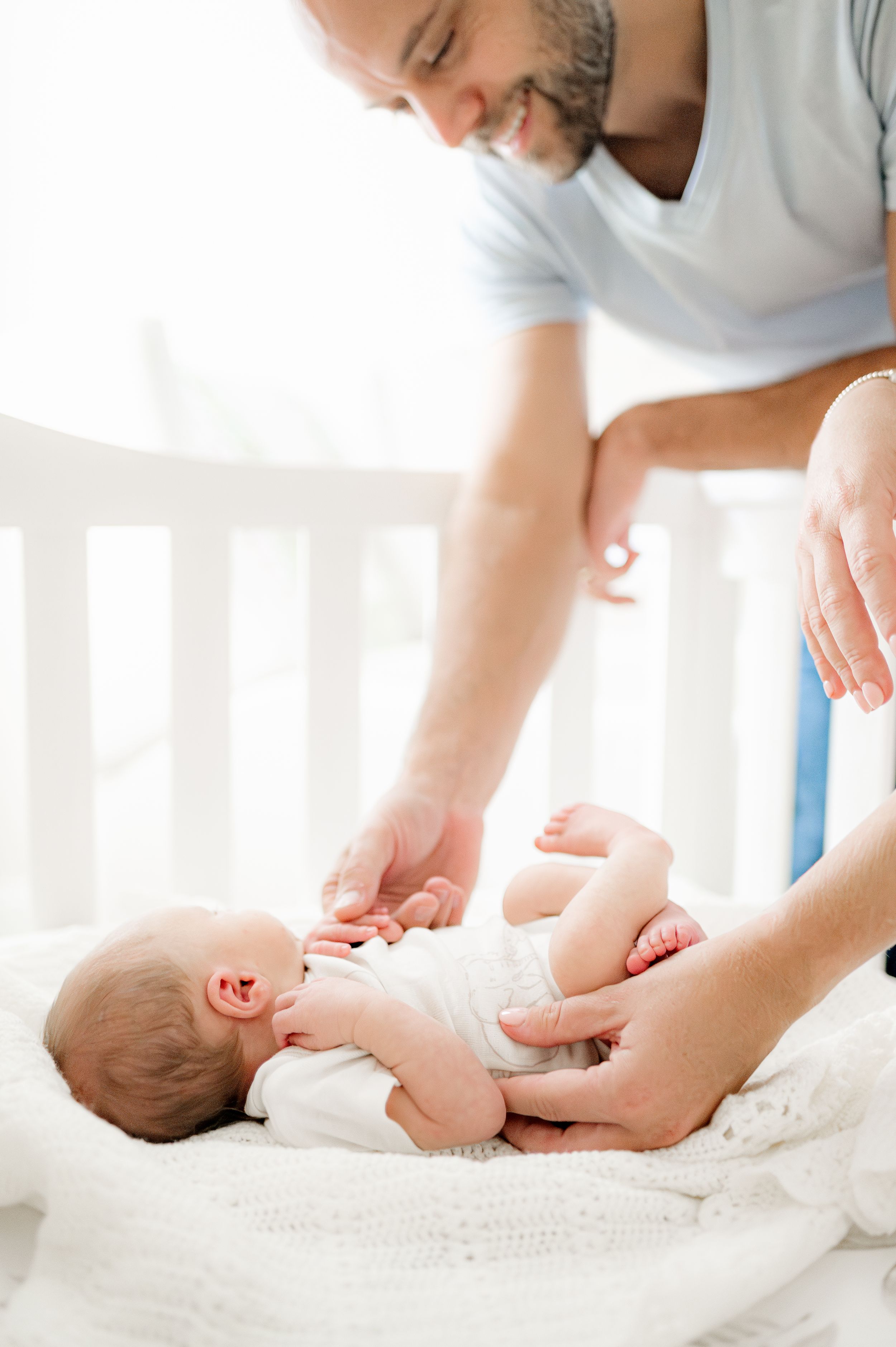 Father playing with newborn baby, taken by Jacksonville baby photographer