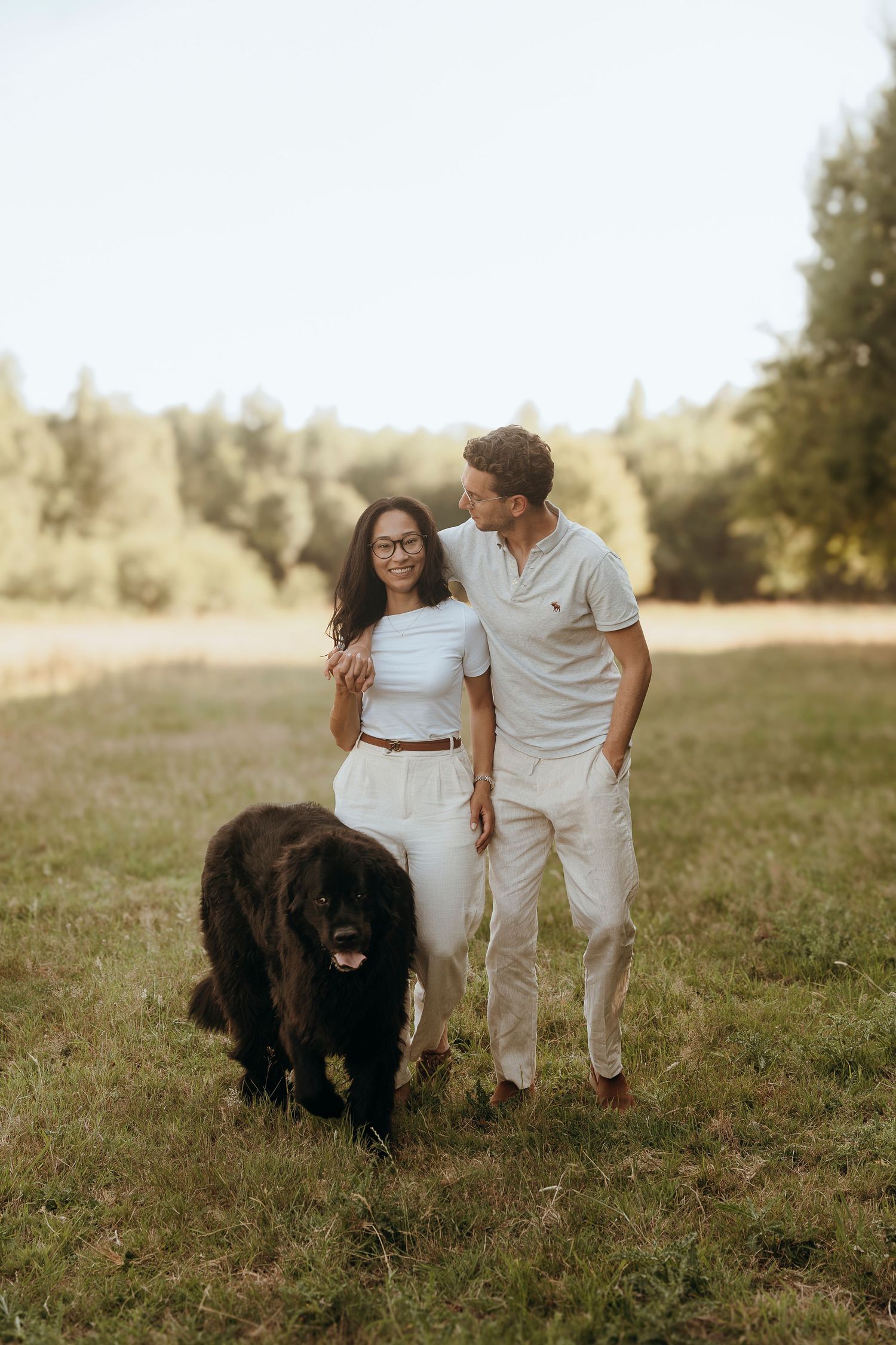 Intimate family portrait outdoors with newborn baby in soft natural lighting.