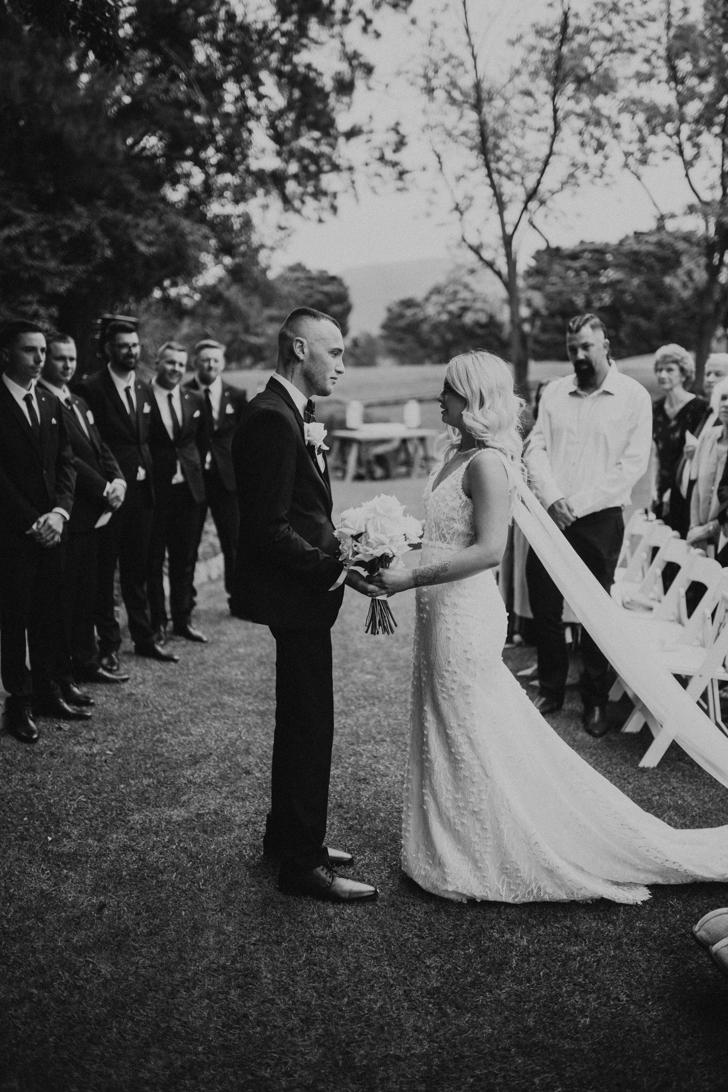 Black and white wedding photo series showing a joyful dance sequence outdoors.
