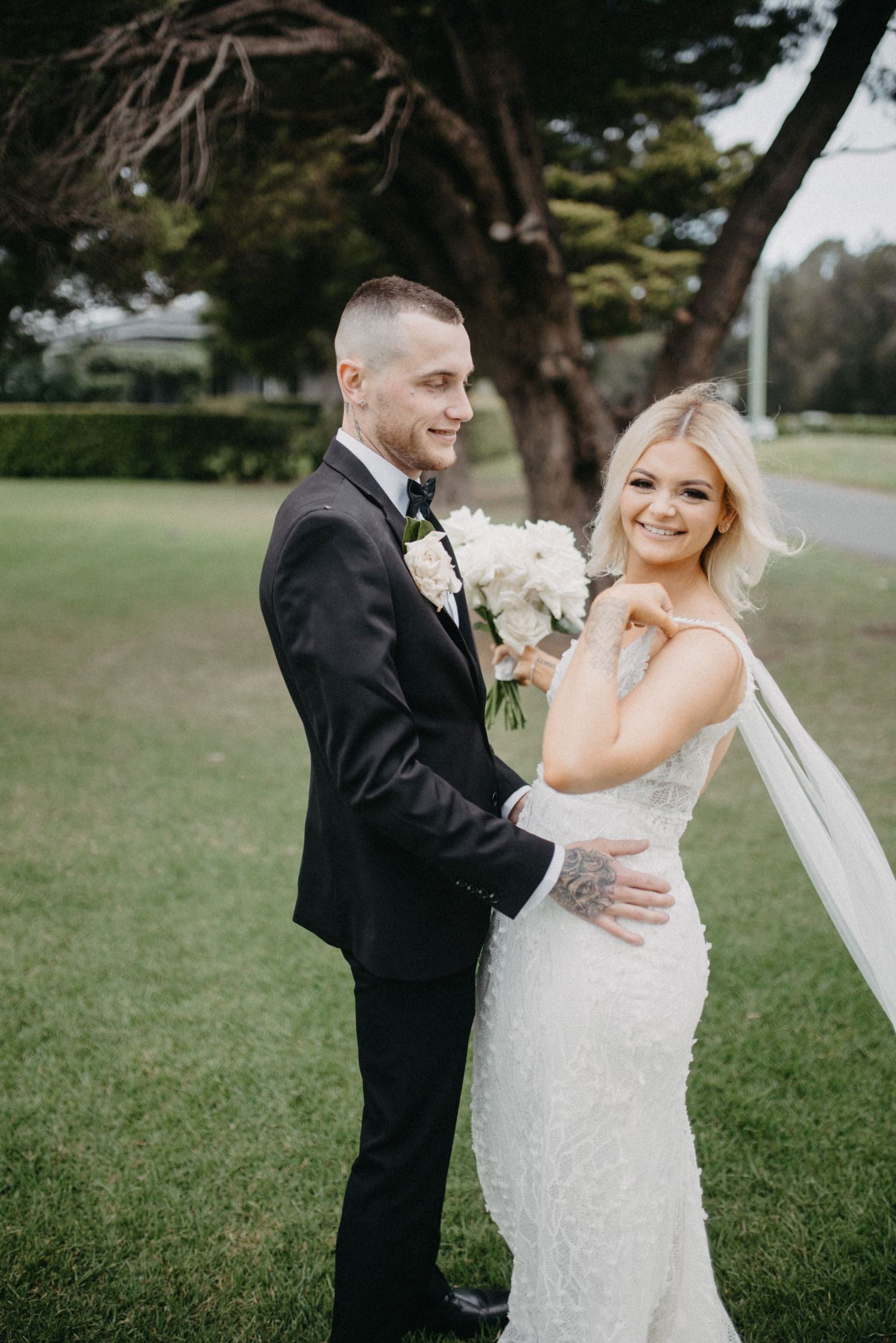 Elegant outdoor wedding photos showing couple dancing and laughing together on grassy lawn.