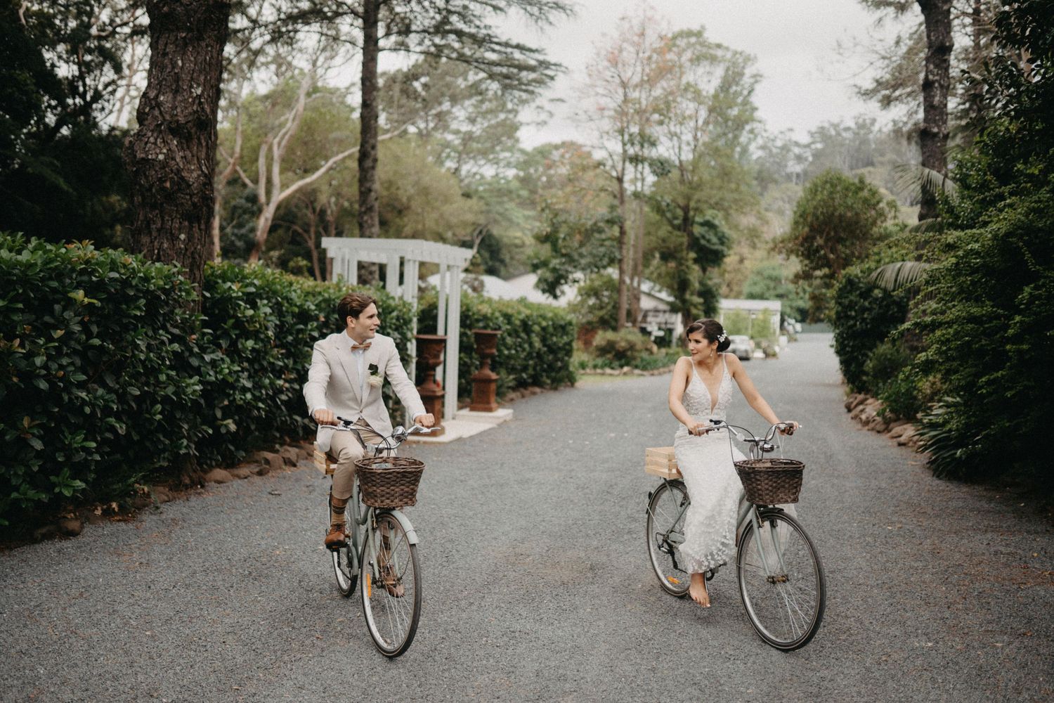 Romantic bike riding scene at a wedding with rustic outdoor venue backdrop.