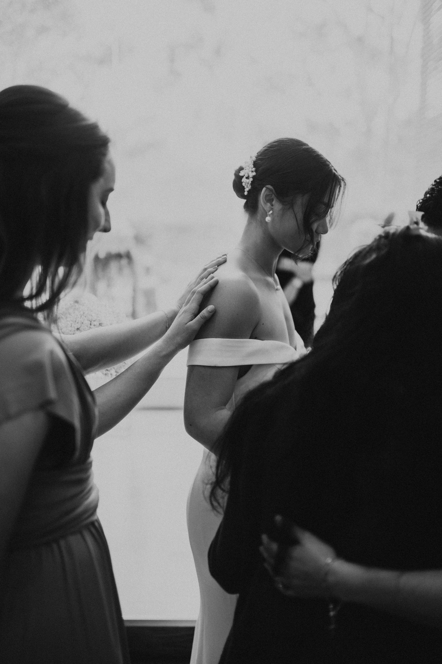 Artistic black and white sequence of wedding preparation moments against white wall.