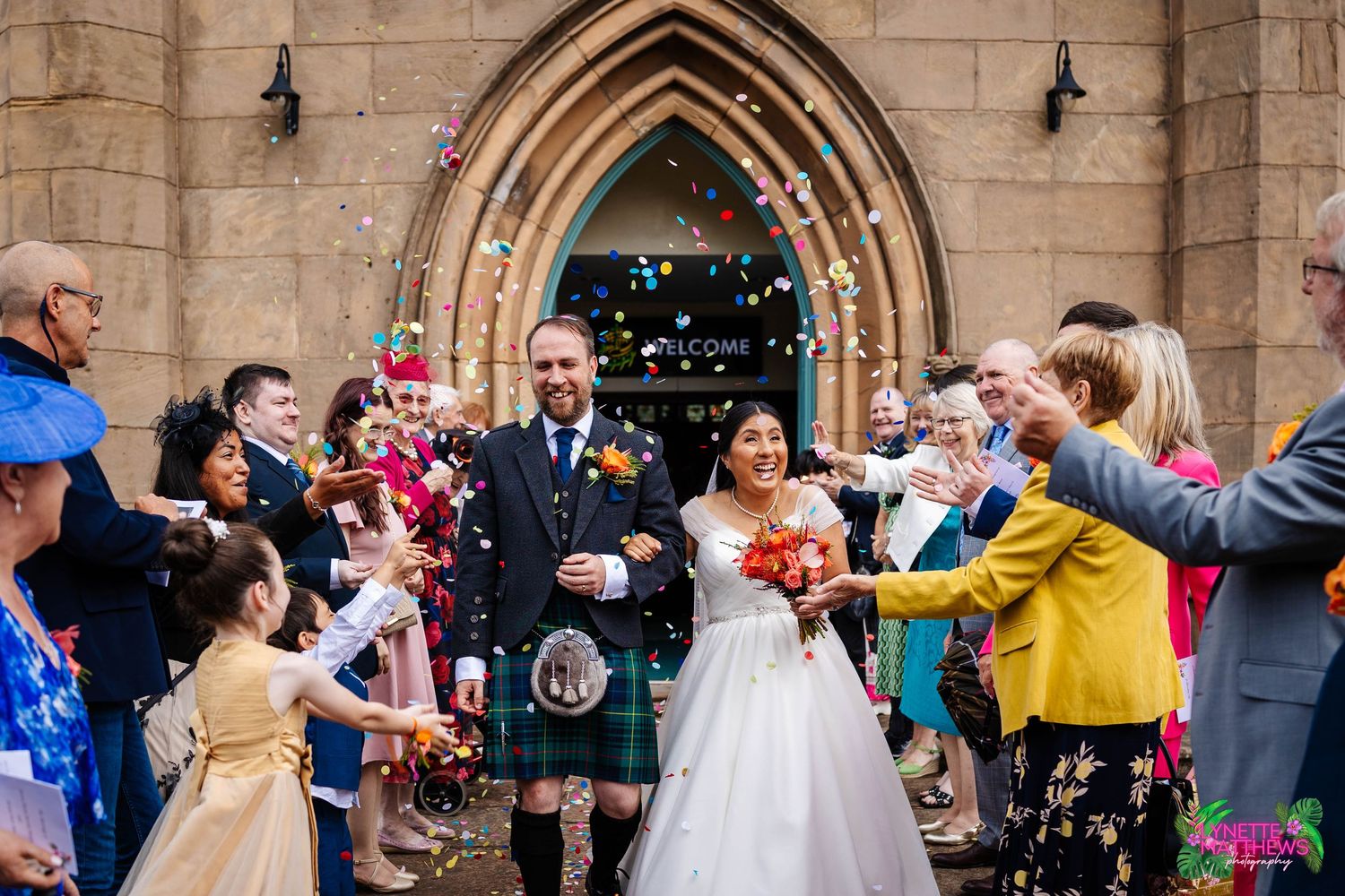 Wedding guests throw confetti at a couple outside a St John's Church, Burscough during a joyful celebration captured by Lynette Matthews