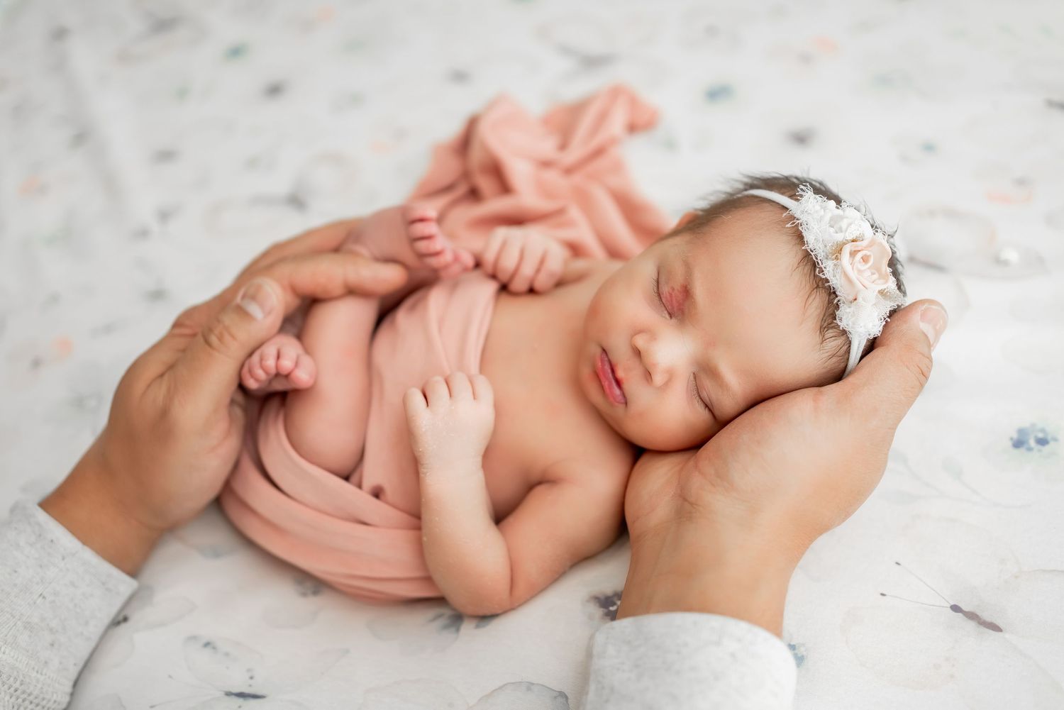 Baby in white outfit crawls on floor with blue and white balloon decorations in bright modern room.