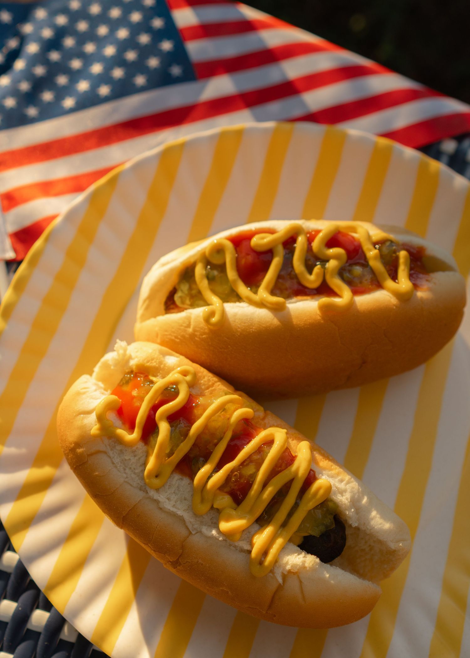 two dressed hotdogs laying on yellow platter