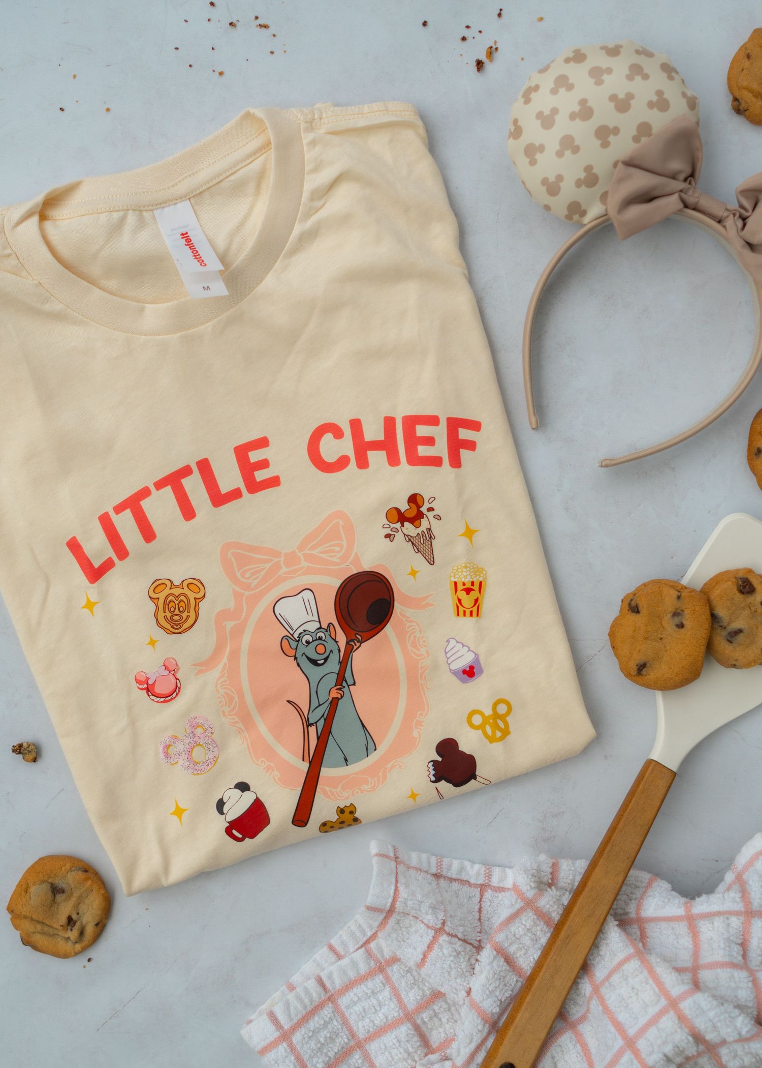 Flay Lay of Little Chef Remi T-Shirt with cookies sprinkled around the shirt