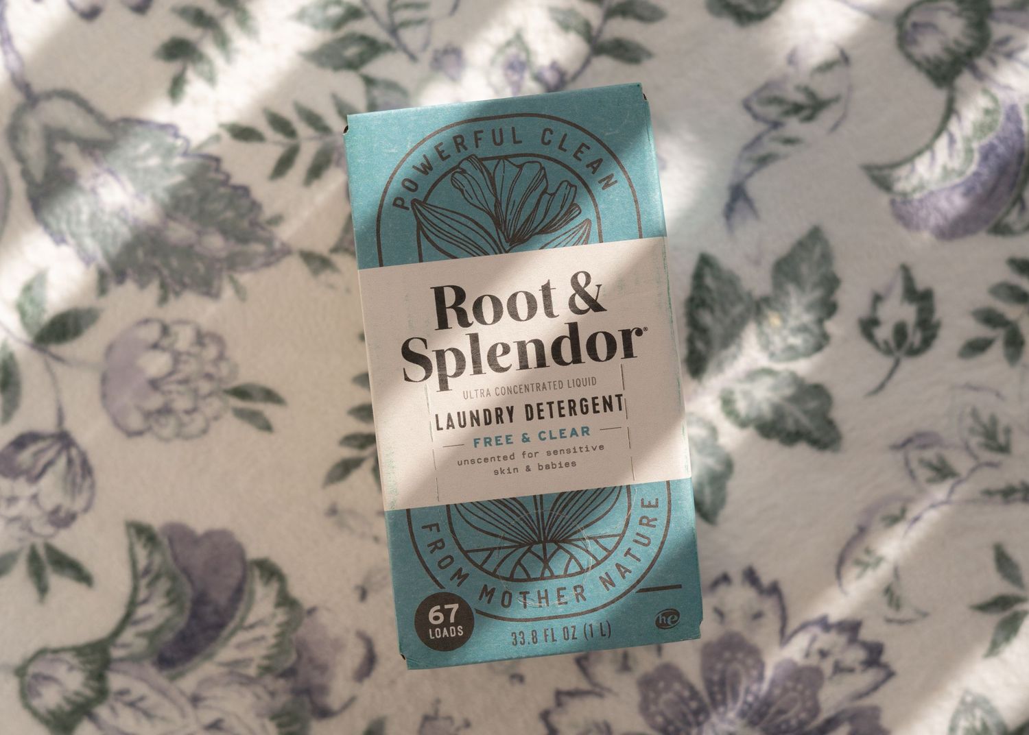 Root and Splendor laundry soap laying on floral rug