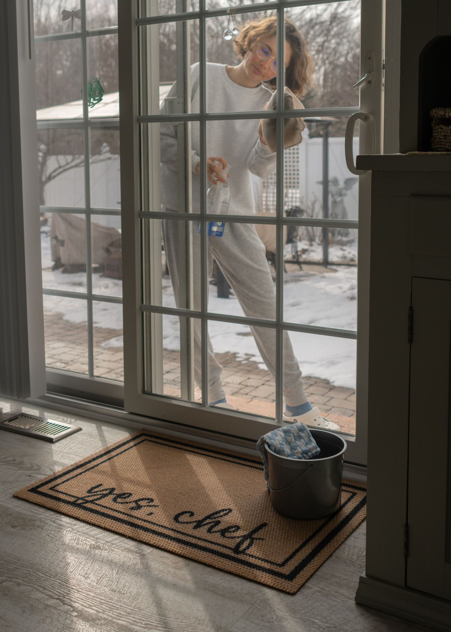 female cleaning sliding glass door window
