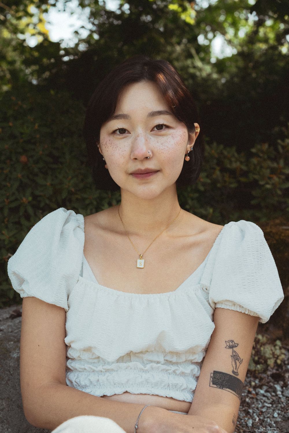A person wearing a white puff-sleeve blouse poses outdoors in a series of cropped portraits.
