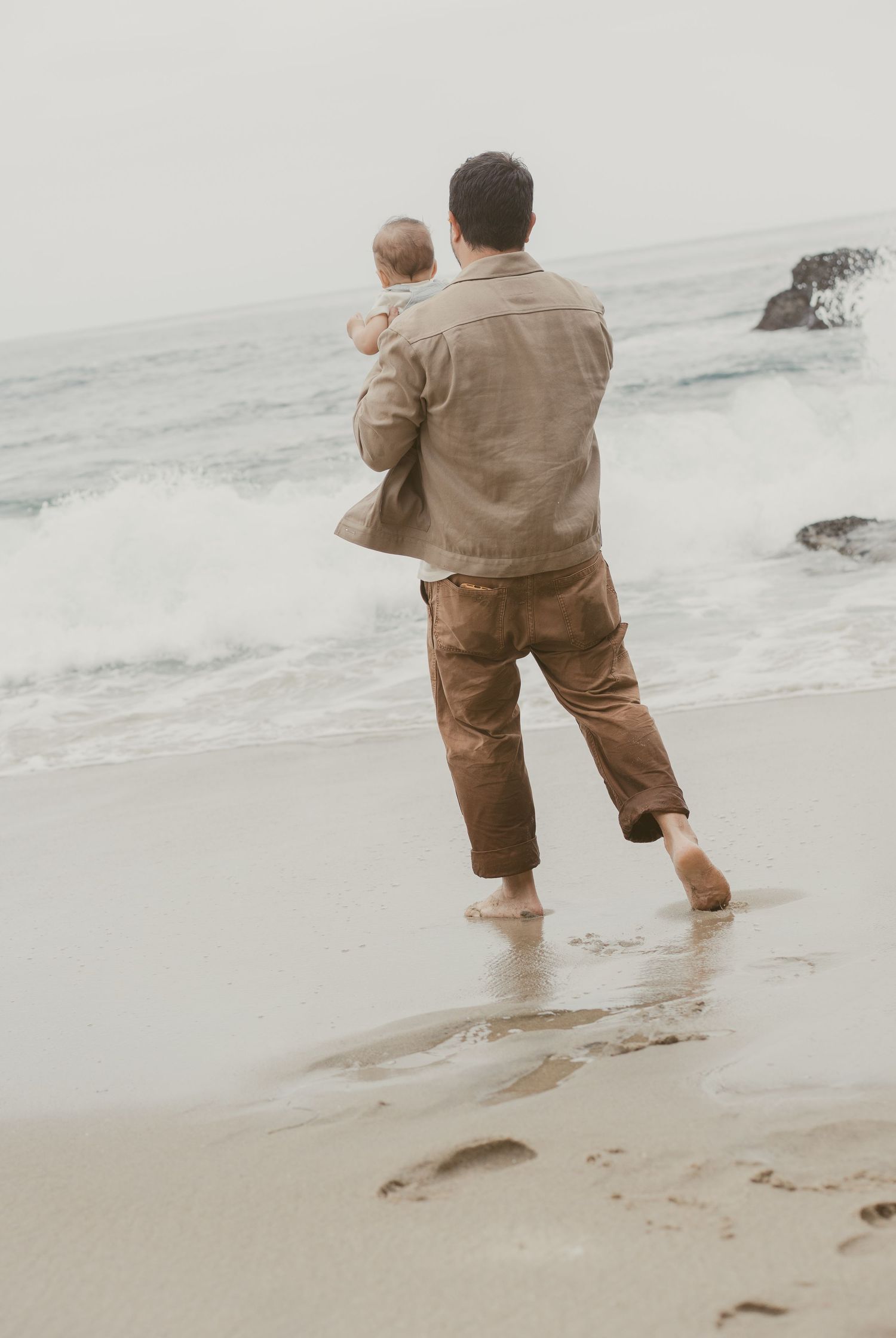 A sequence of photos shows someone in brown clothing walking away from the camera along a misty beach shoreline.