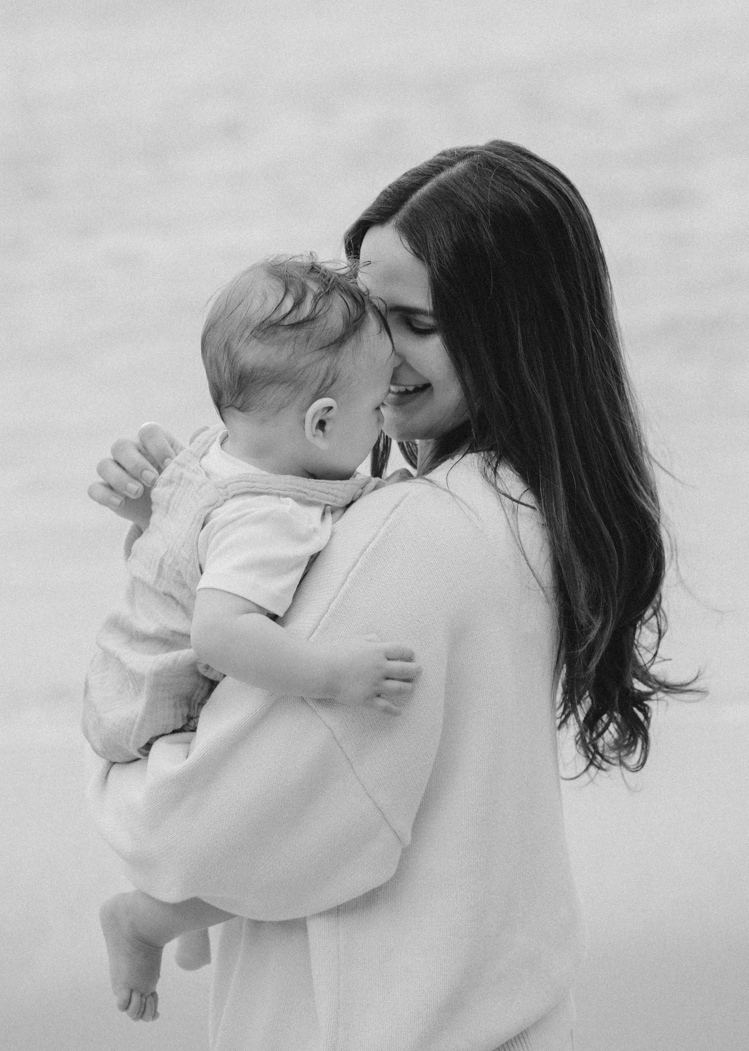 A series of black and white photographs showing tender moments between parent and young child in soft natural light.