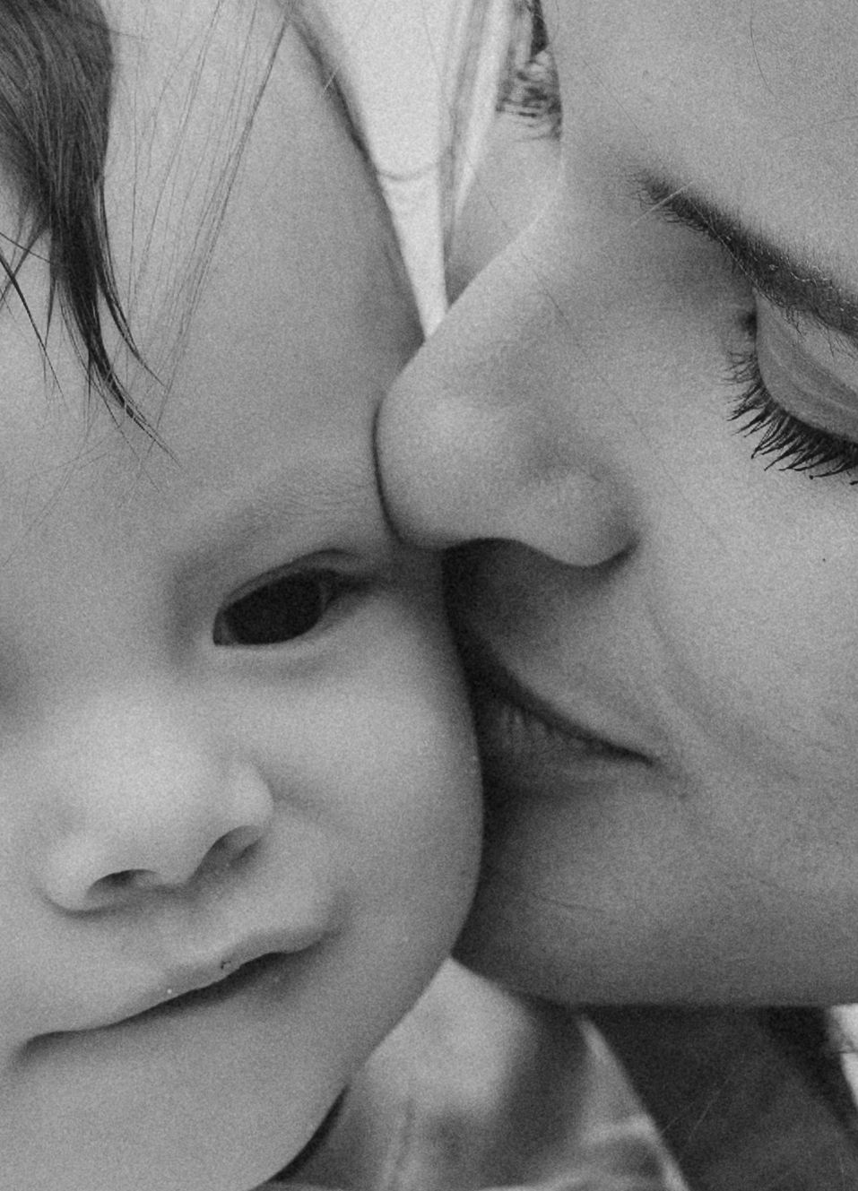 A black and white close-up photograph showing a tender kiss between two people.