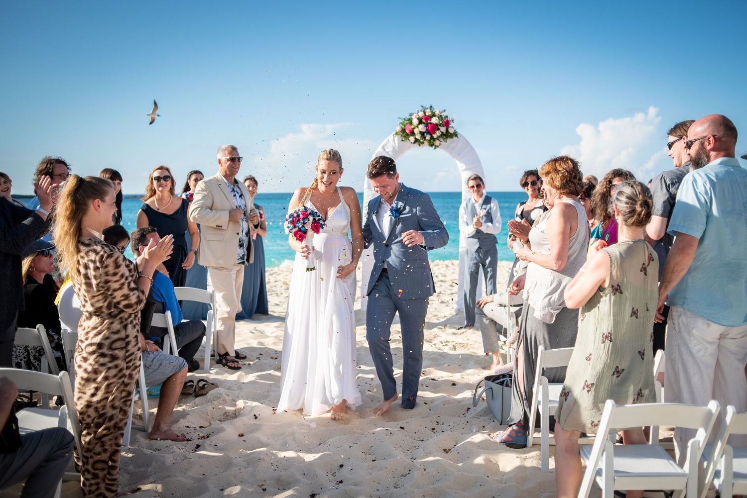 Candid moment of couple running together post-ceremony at beachside destination wedding.