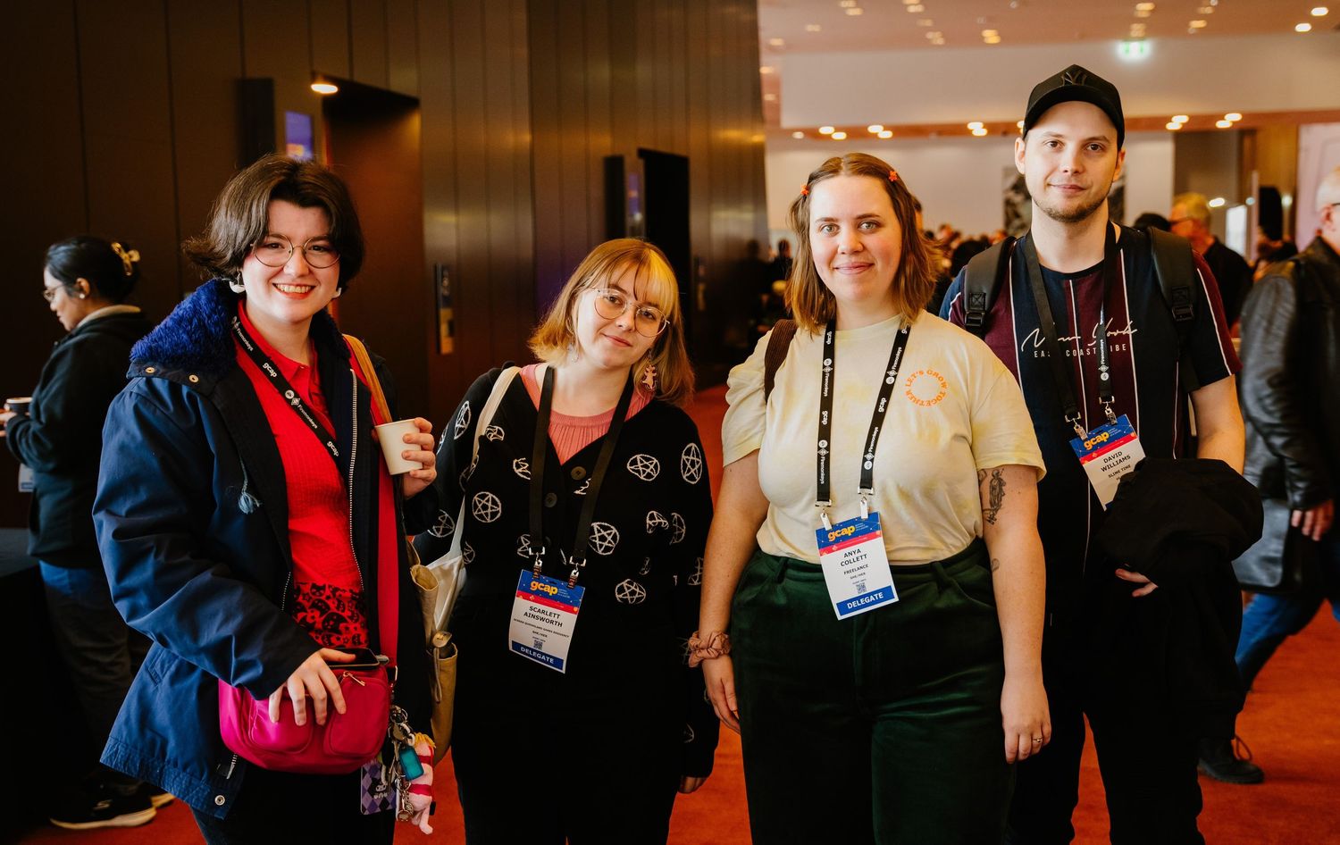 Group of conference attendees standing together and smiling in a hotel lobby with name badges.