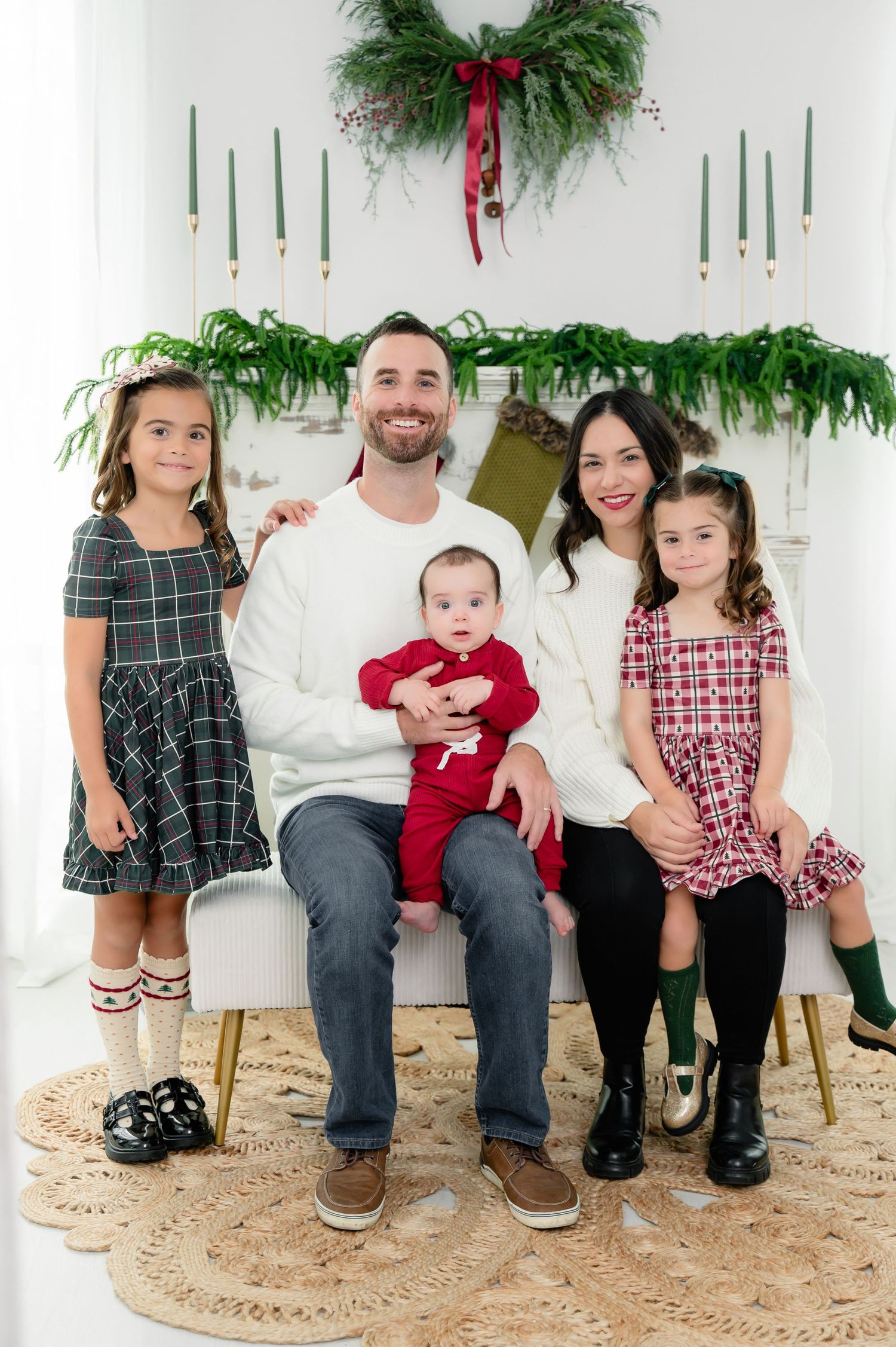A holiday portrait sequence shows a family sitting together with festive evergreen decor and red accents against a white wall.