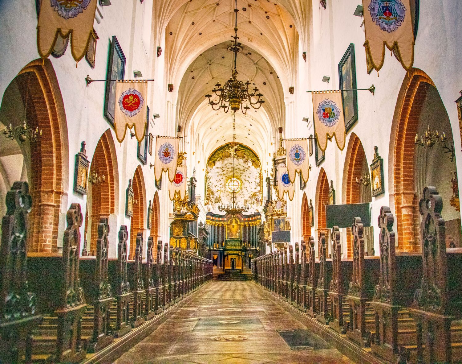 Gothic church interior with arched ceilings and ornate decorations along empty corridor.