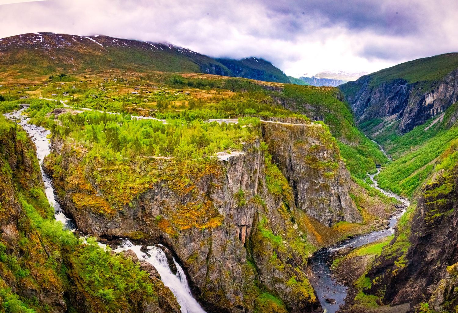 Dramatic mountain valley landscape with waterfalls and winding river through Norwegian fjords.