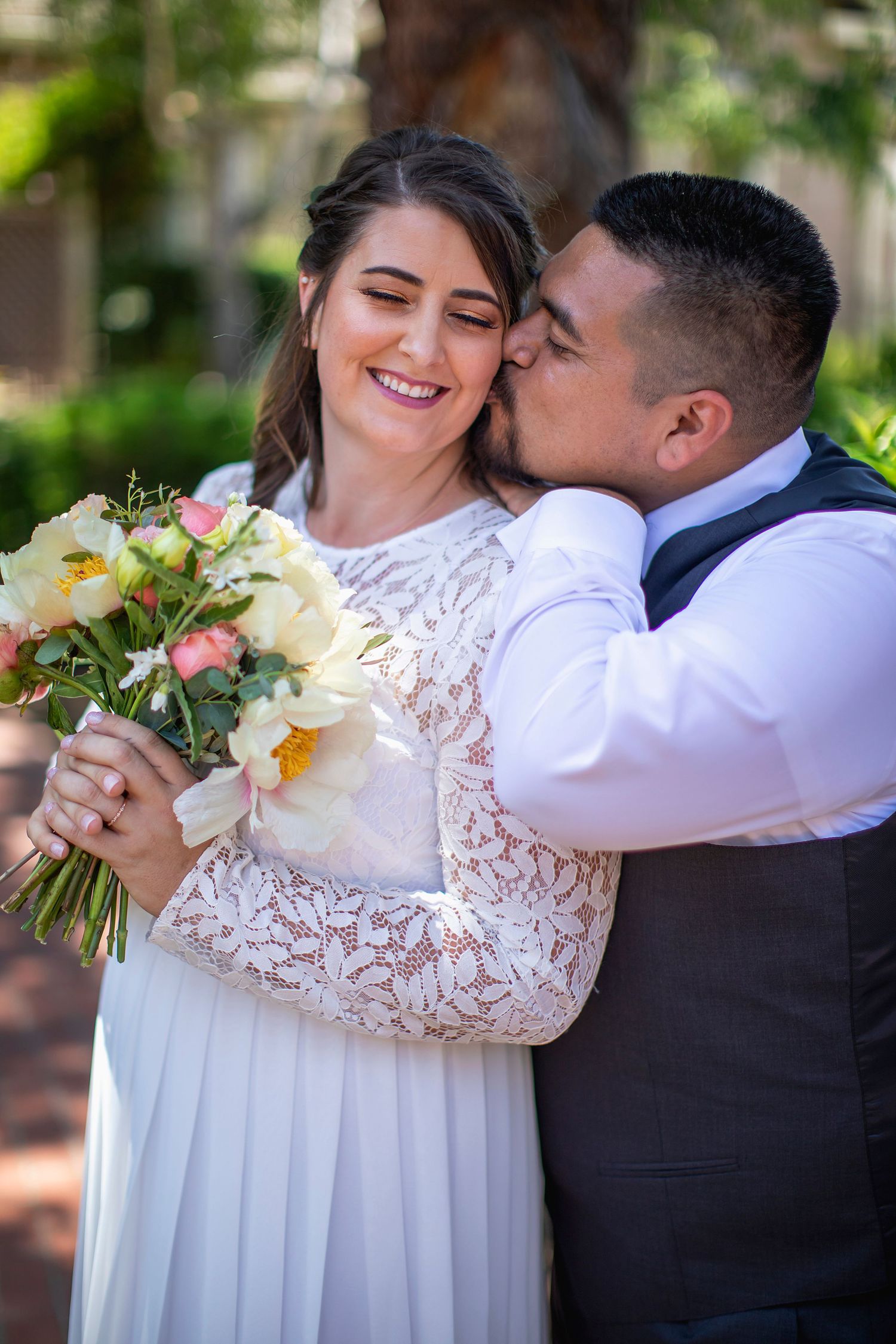 Romantic wedding portraits showing tender moments between newlyweds with floral bouquet.