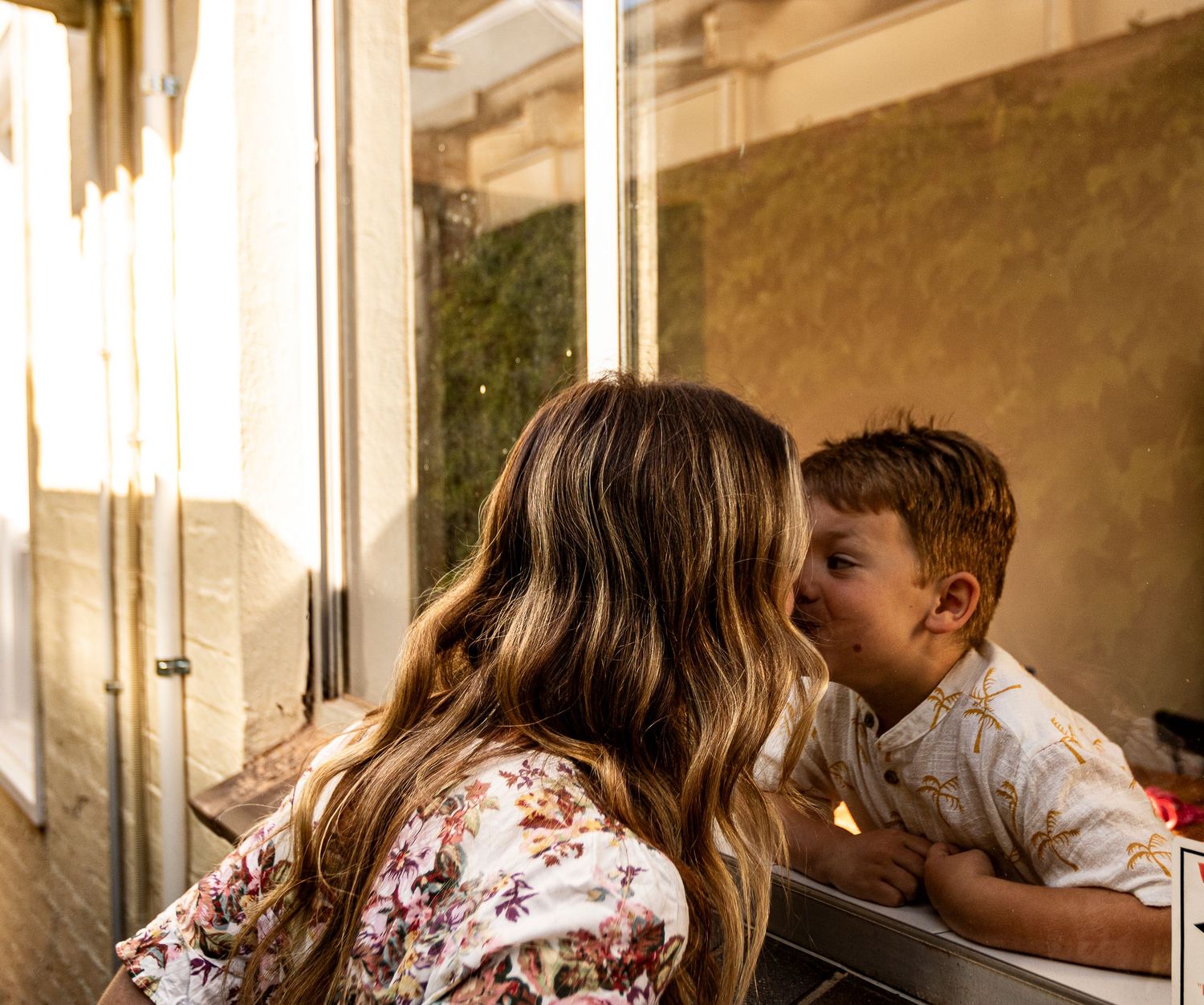 A tender moment captured in warm natural light indoors.