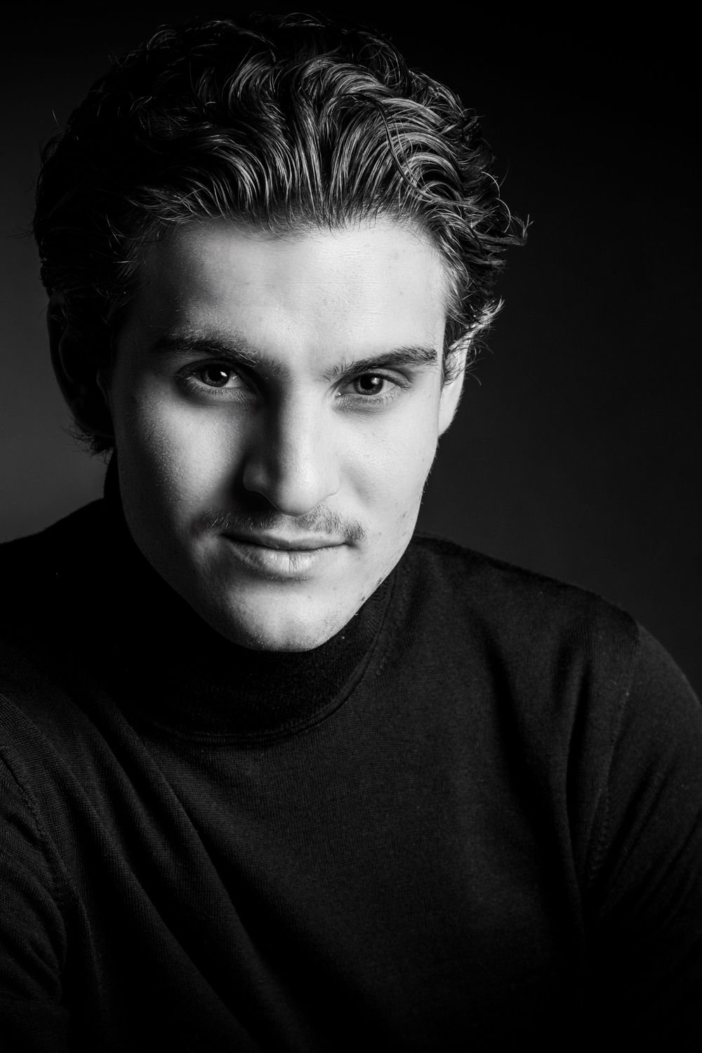 Schwarz-Weiß-Portrait eines jungen Mannes im Rollkragenpullover im Fotostudio Gelsenkirchen-Hassel – stilvolles Studiofoto
