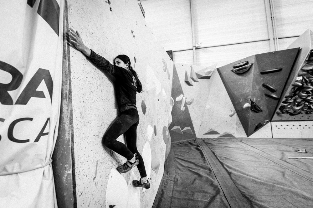 American professional rock climber Natalia Grossman trains on an indoor climbing wall in Paris, France, wearing athletic gear.