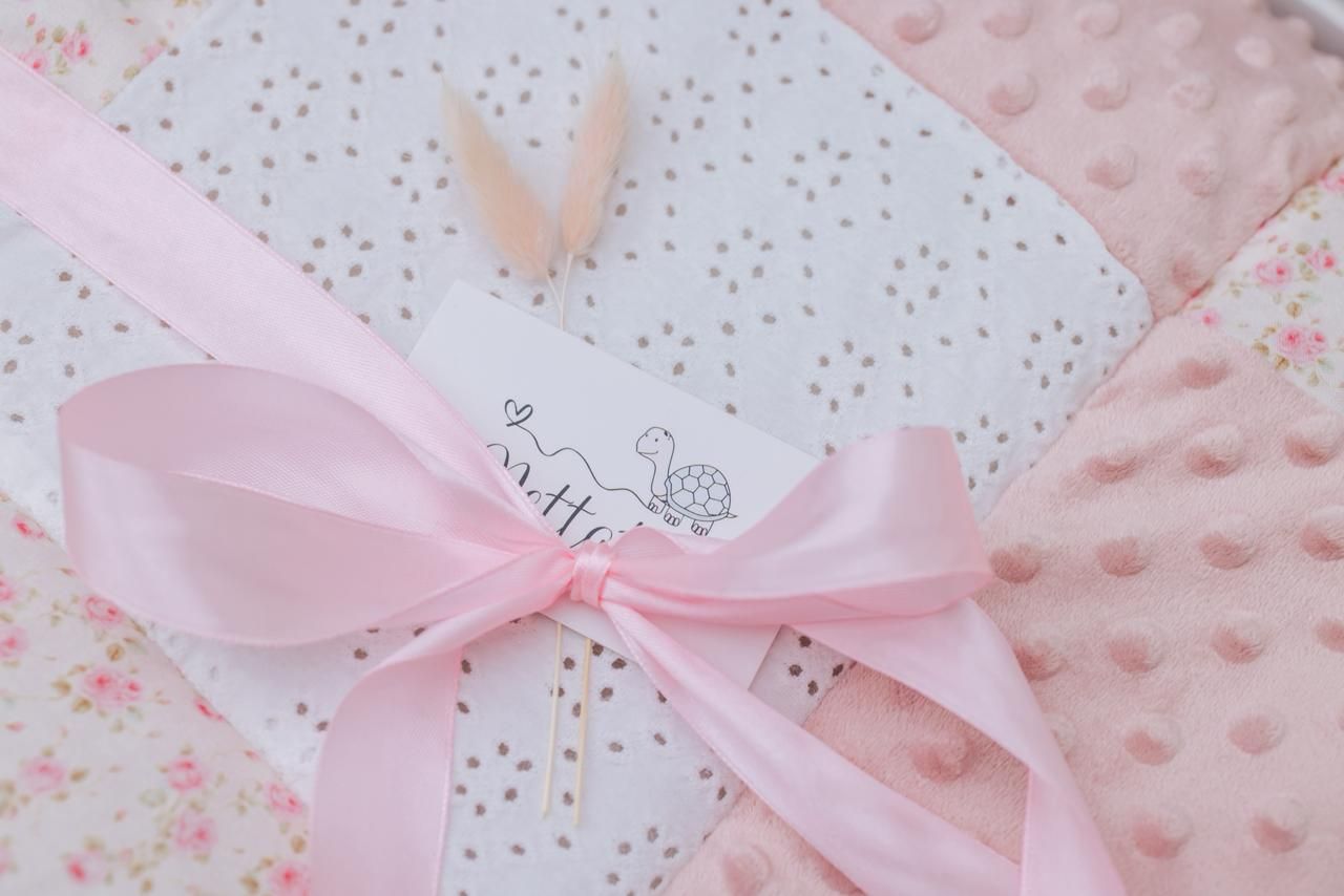 Pink satin bows adorn delicate white lace fabric with a romantic and feminine aesthetic.