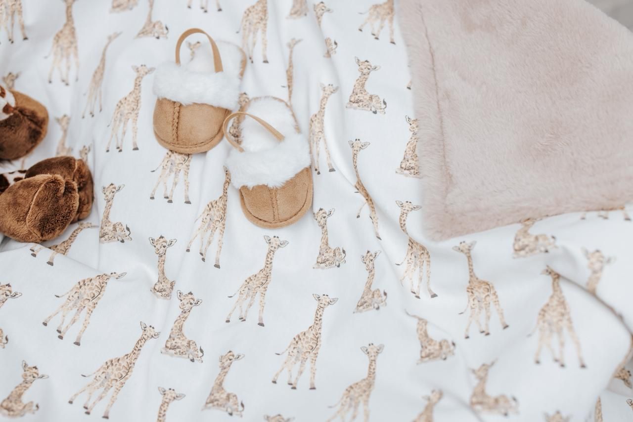 A seamless pattern of brown and beige giraffe illustrations on a light background.