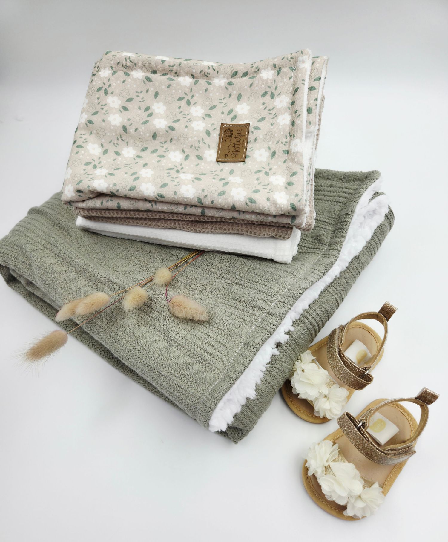 Vintage-style floral blanket with sage green knit fabric and metallic gold sandals.