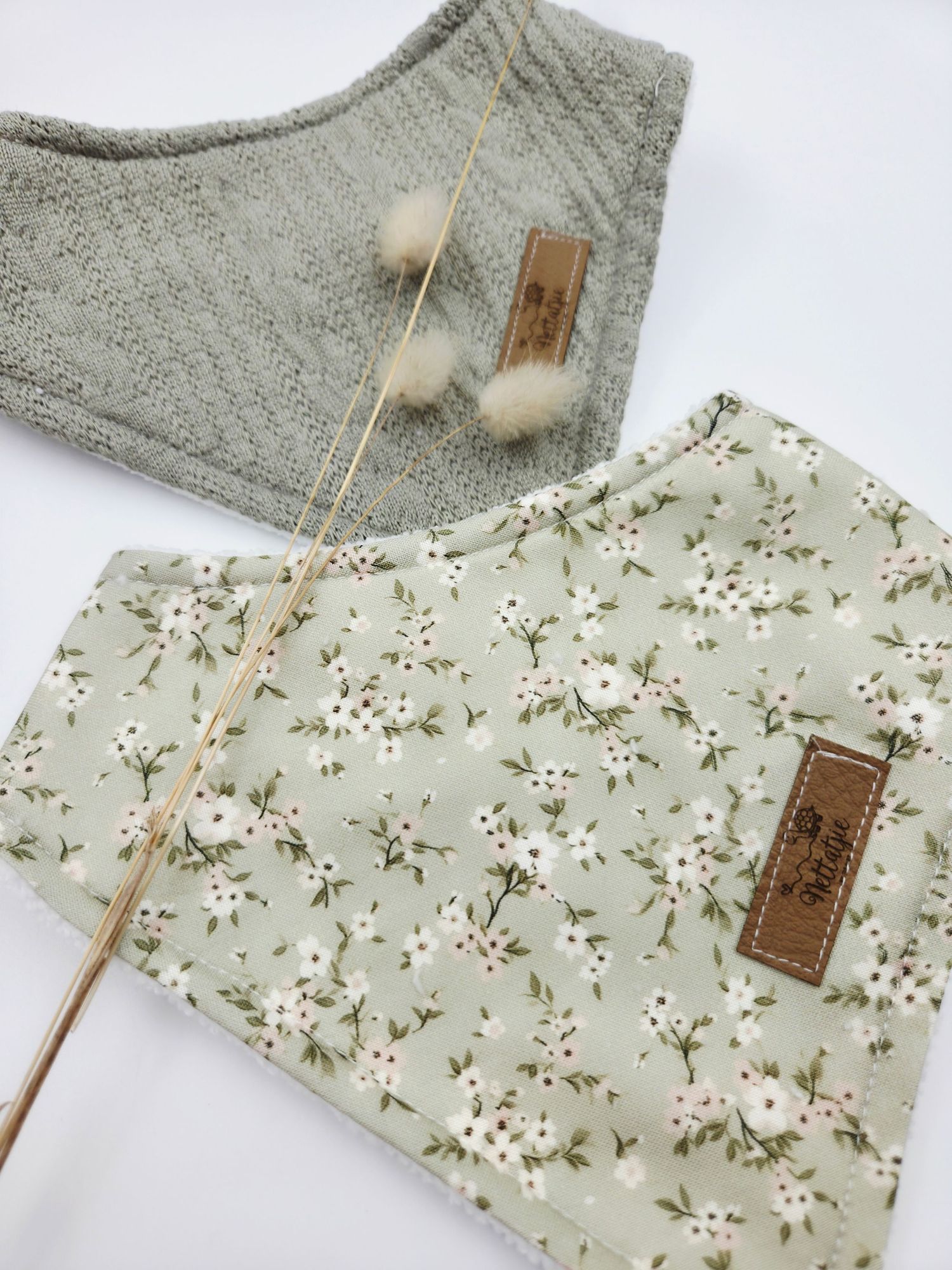 Gray knit sweater and sage green floral print baby clothing with leather tags.
