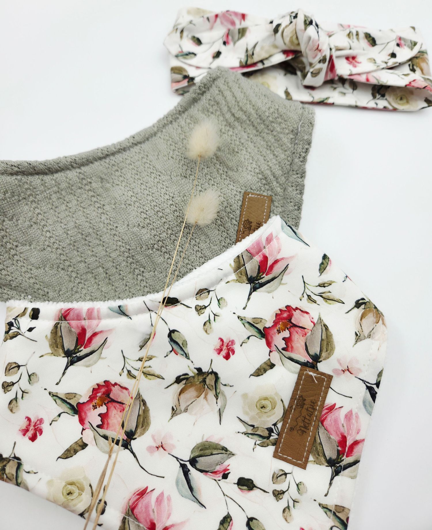 Baby clothing featuring pink floral prints and gray knit fabric with leather accents.