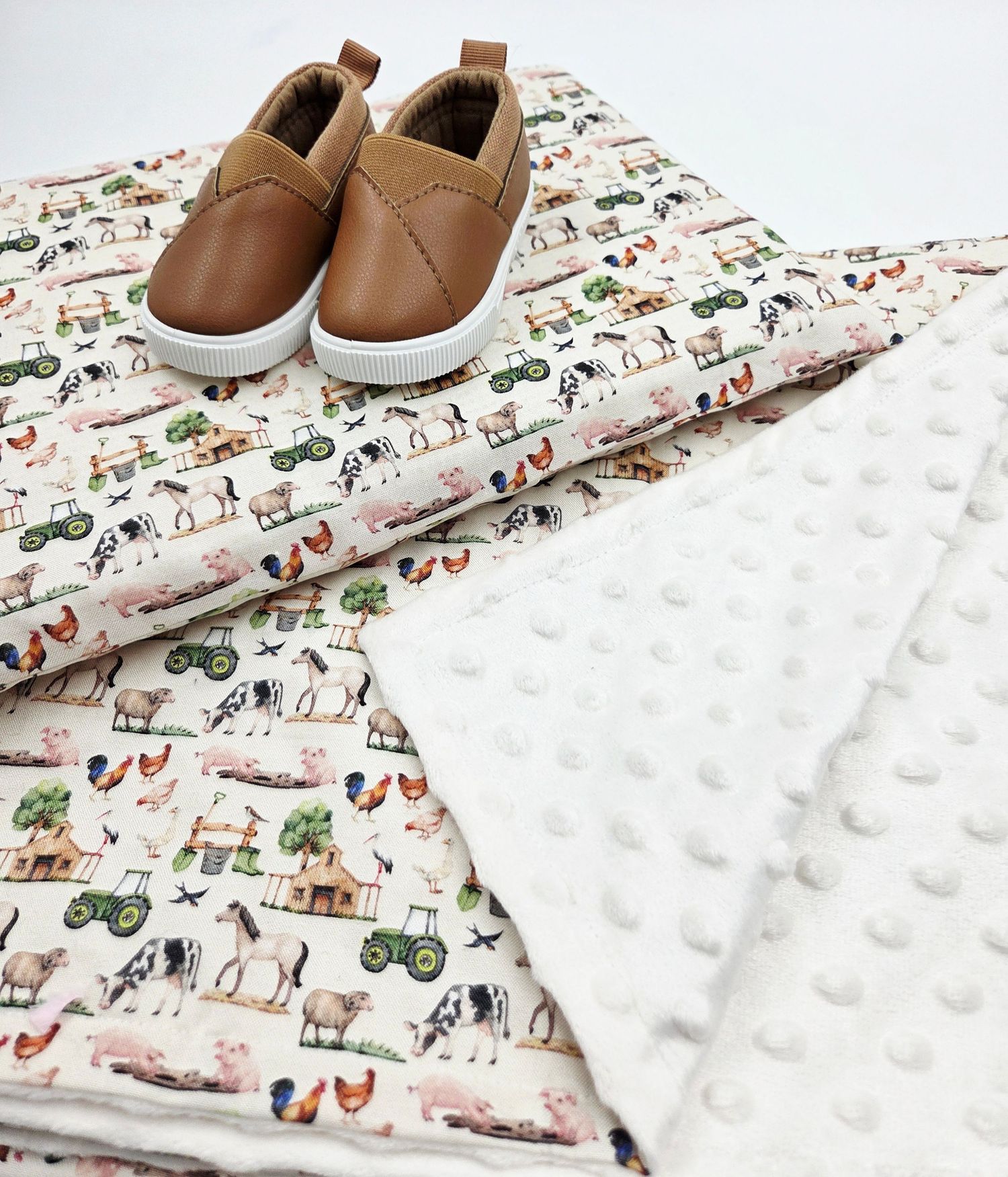 White minky dot blanket paired with farm animal print fabric and leather baby shoes.