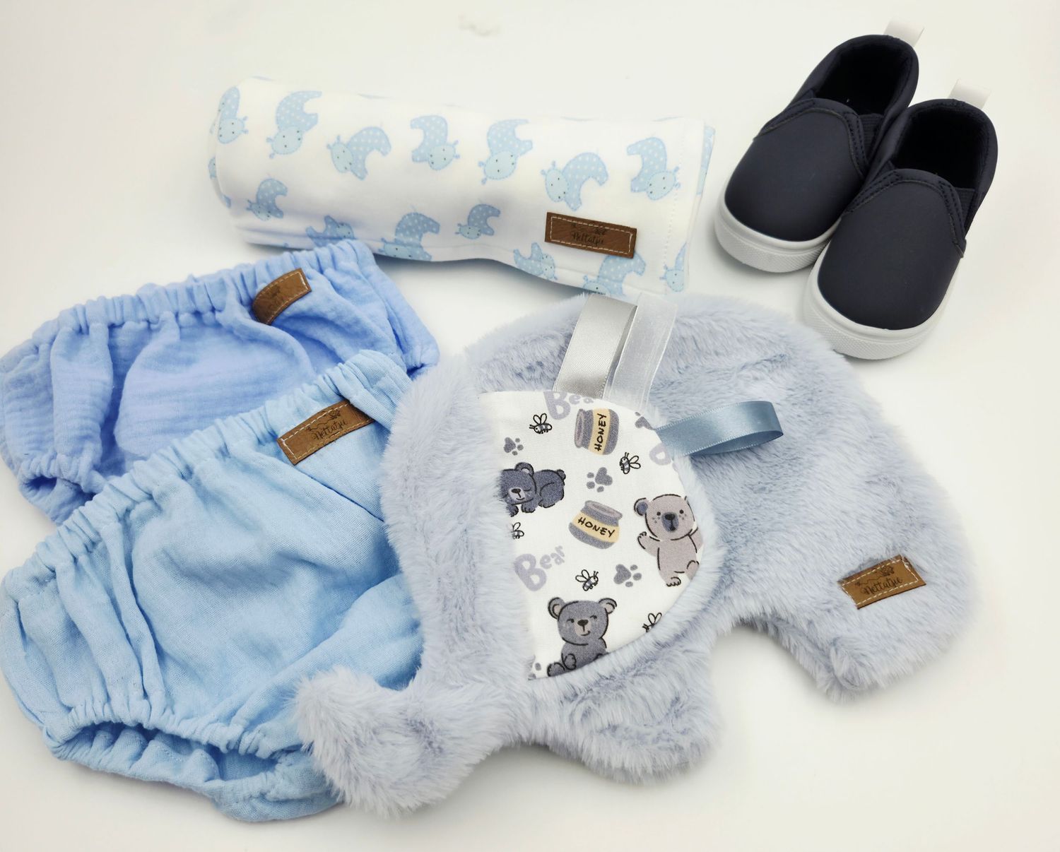 Baby blue diaper covers and matching accessories arranged in a row on white background.