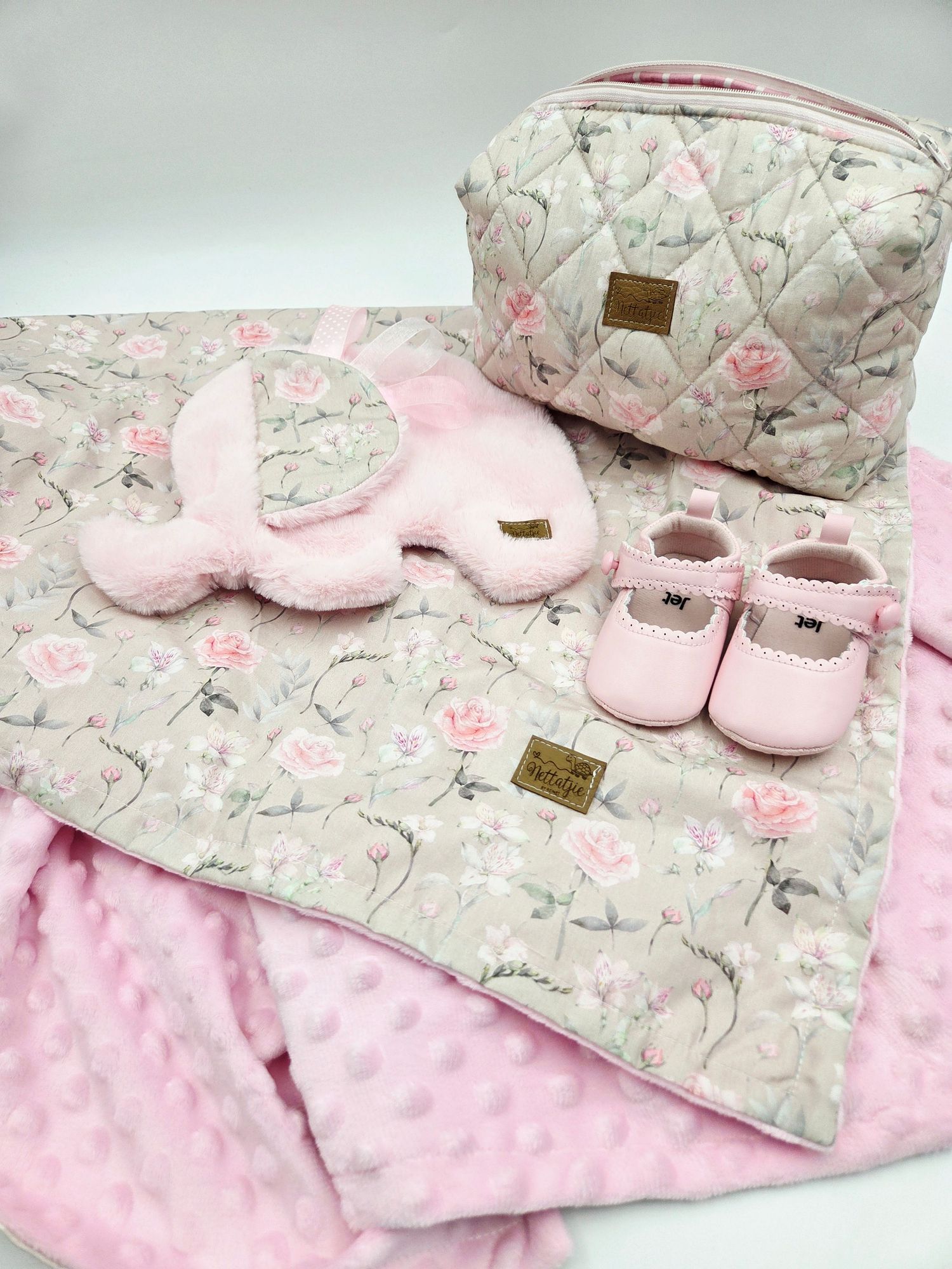 Pink and gray floral baby blanket set with matching shoes on white background.