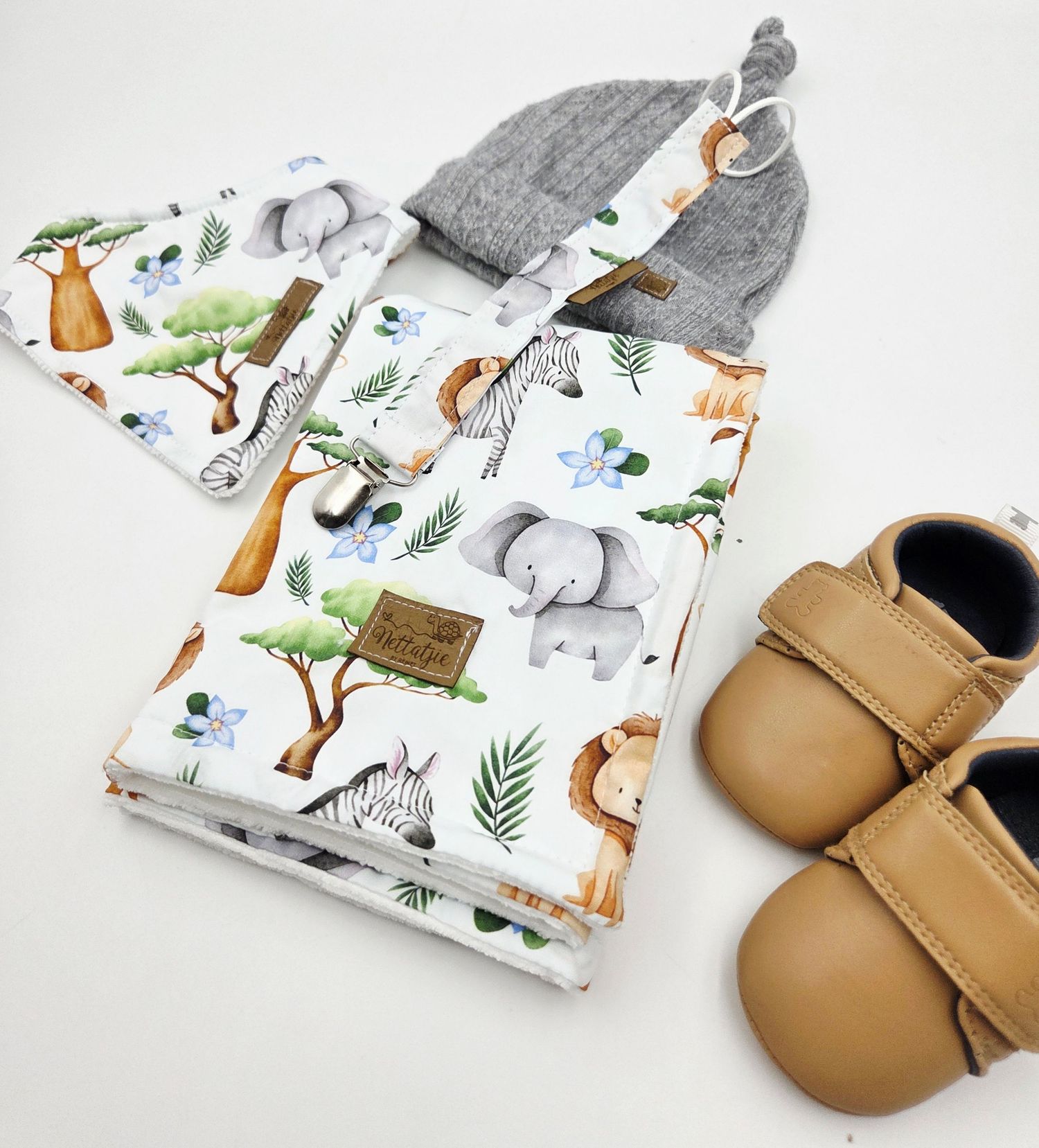Handmade baby moccasins and matching animal print blanket displayed on white background.