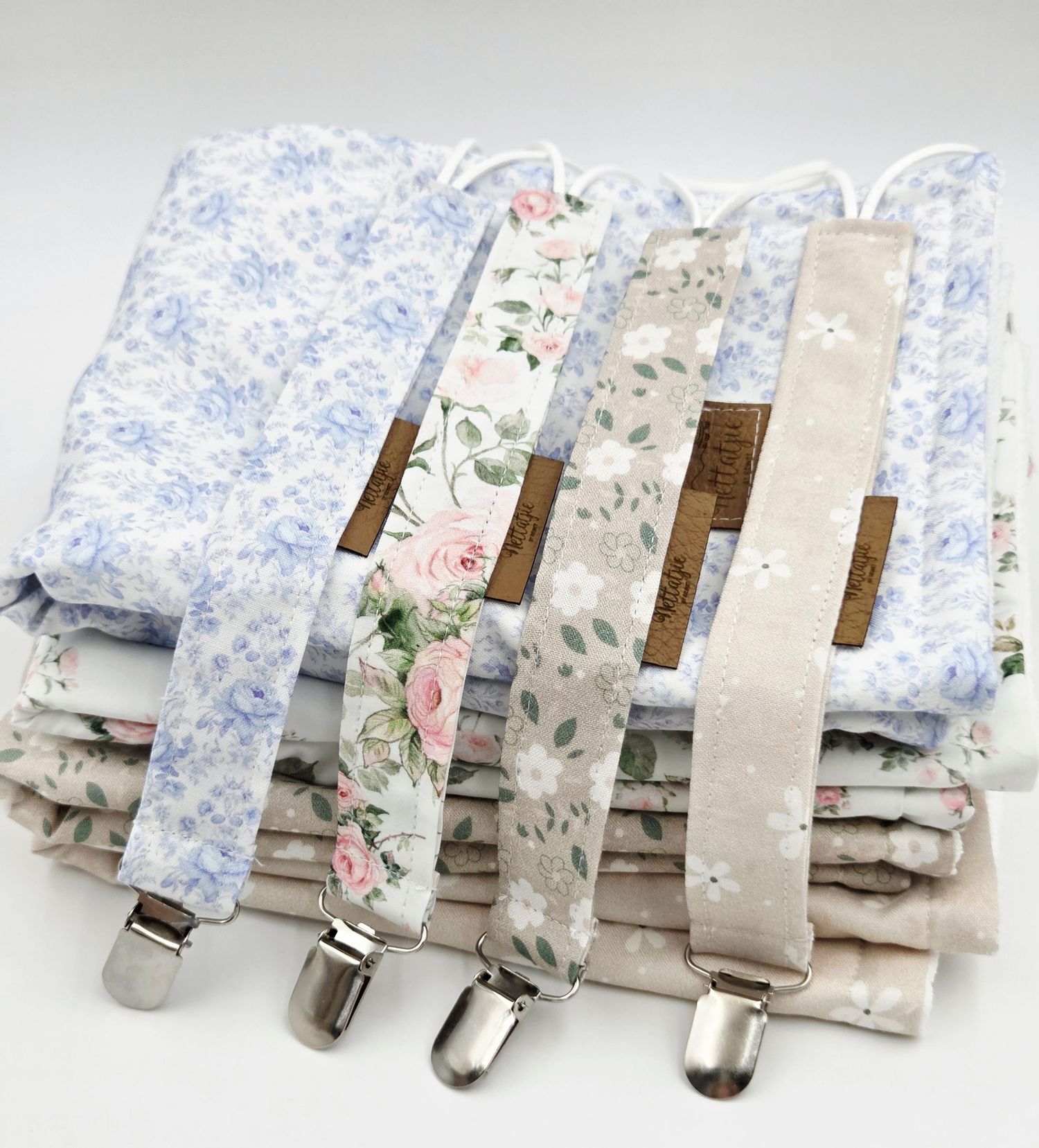 Set of delicate floral print baby accessories with matching clips arranged in a row.