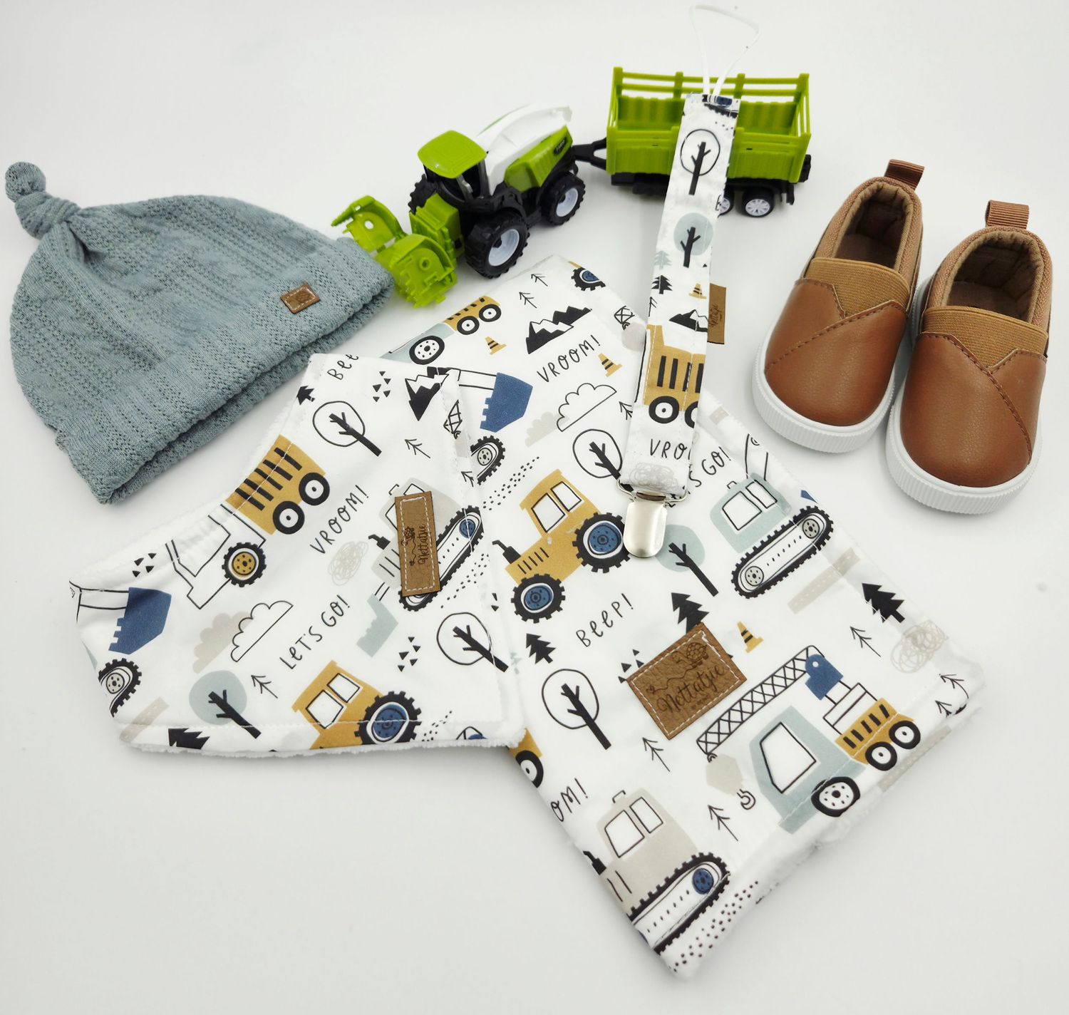 Baby blanket and accessories collection featuring blue transportation pattern with matching brown leather shoes.