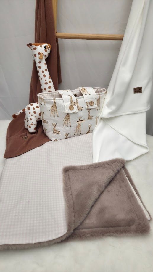 Baby giraffe-themed diaper bag set with stuffed giraffe toy, waffle blanket, and plush taupe blanket on white background.